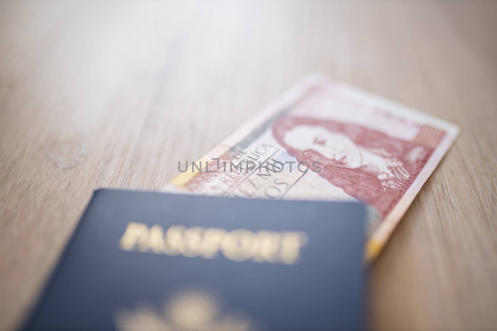 United States of America Passport with half a 10.000 Colombian Pesos Bill Inside, showing the Face of Policarpa Salavarrieta