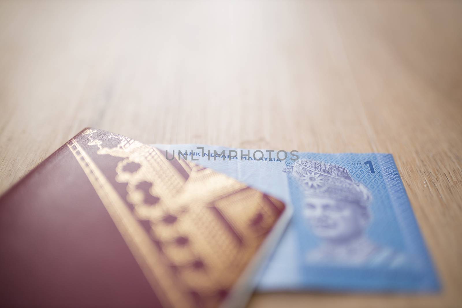Picture of a One Malaysian Ringgit Note Inside a Sweden Passport, showing the face of the king Abdul Rahman