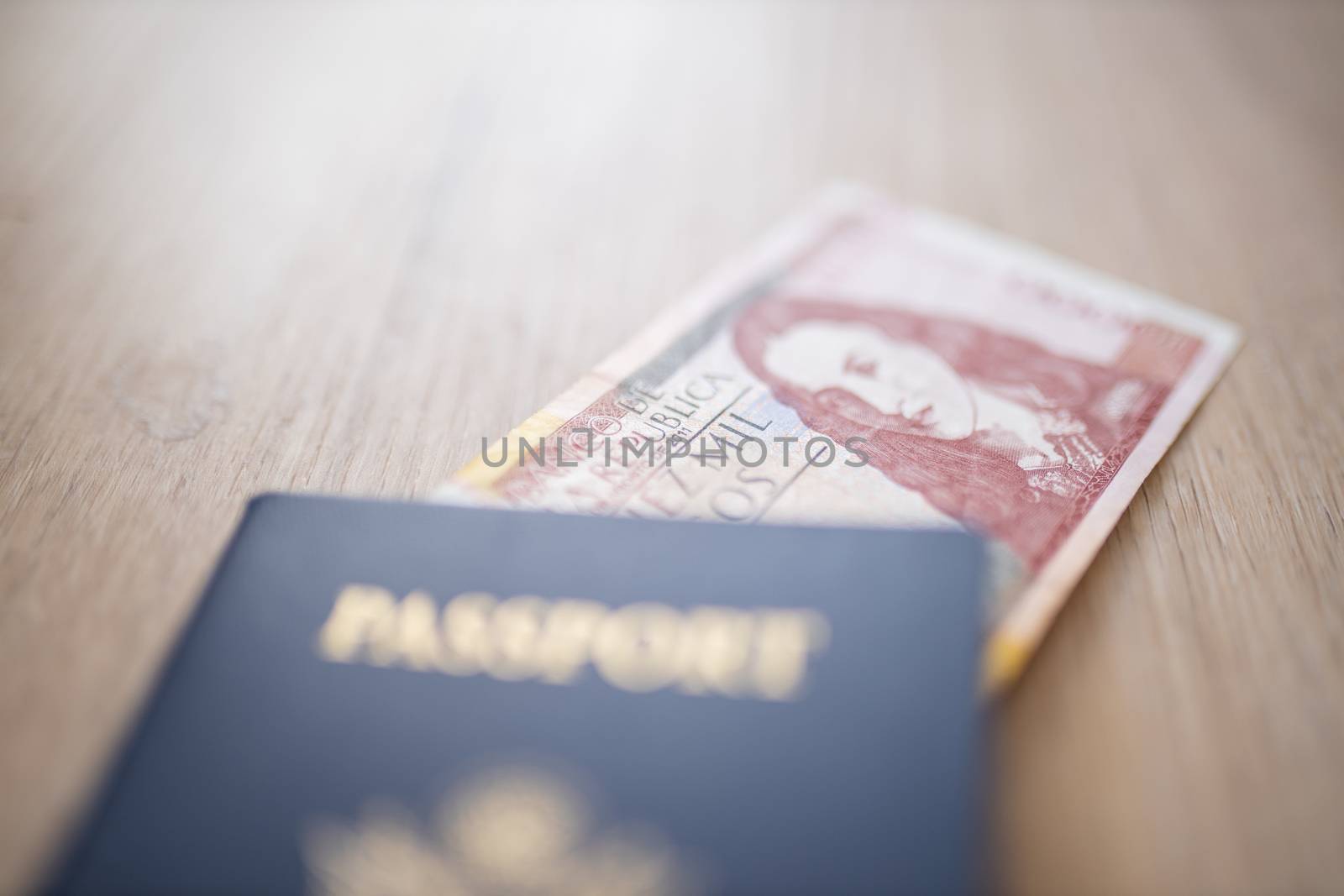 United States of America Passport with half a 10.000 Colombian Pesos Bill Inside, showing the Face of Policarpa Salavarrieta