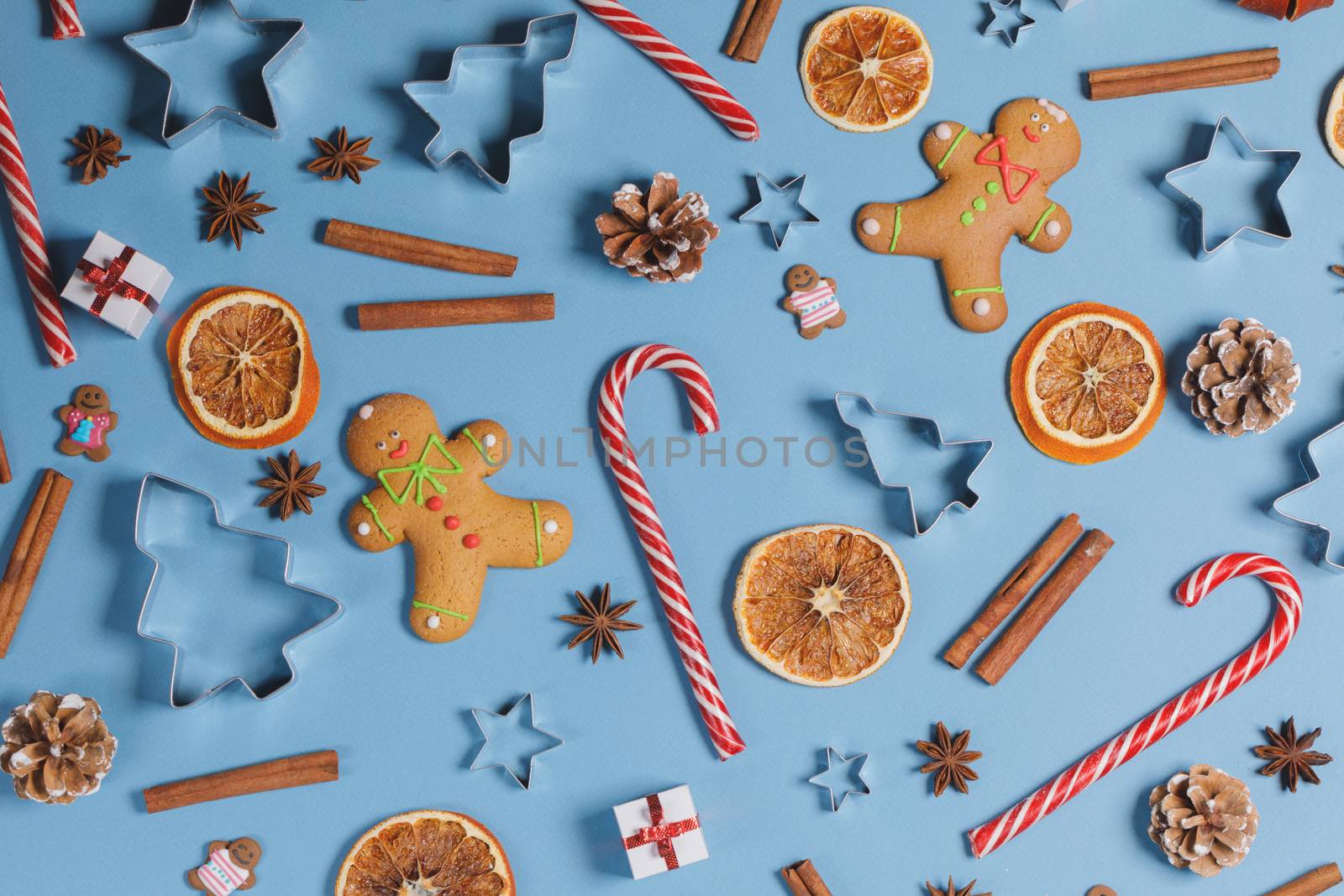 Christmas food frame. Gingerbread cookies, spices and decorations on blue background with copy space