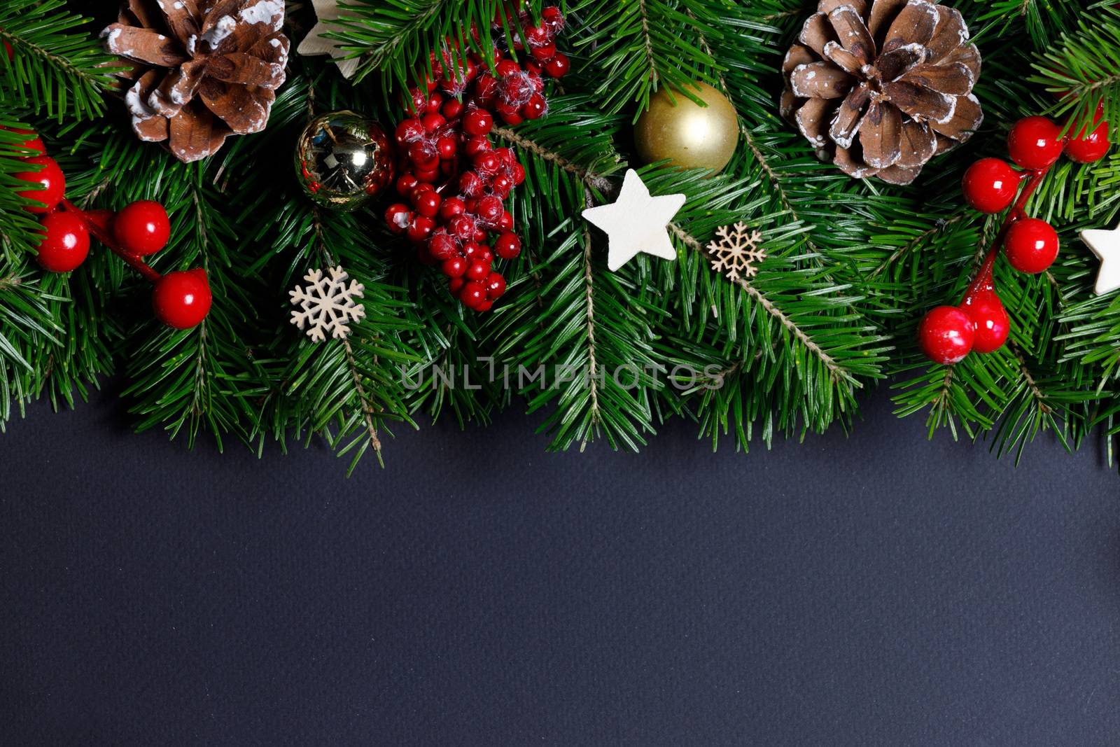 Natural fir Christmas tree border frame with decor on black, copy space for text