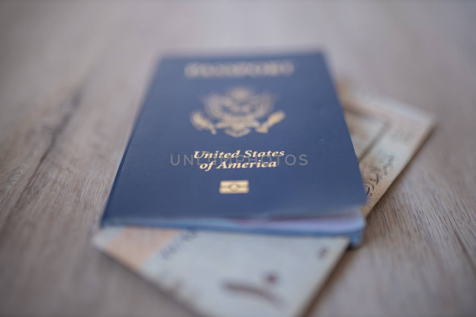 Picture of a United States of America Passport with a blurry Ten Saudi Riyals Bill Partially Inside