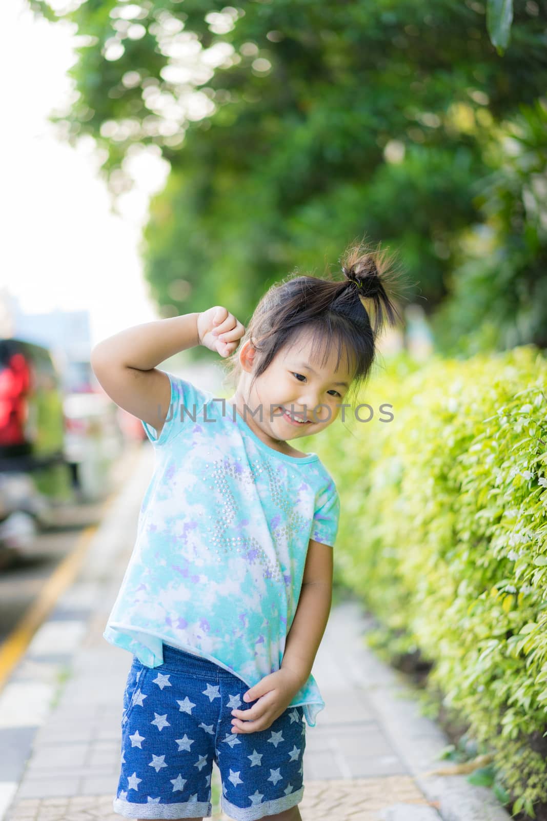 portrait of happy little girl standing ing in the park