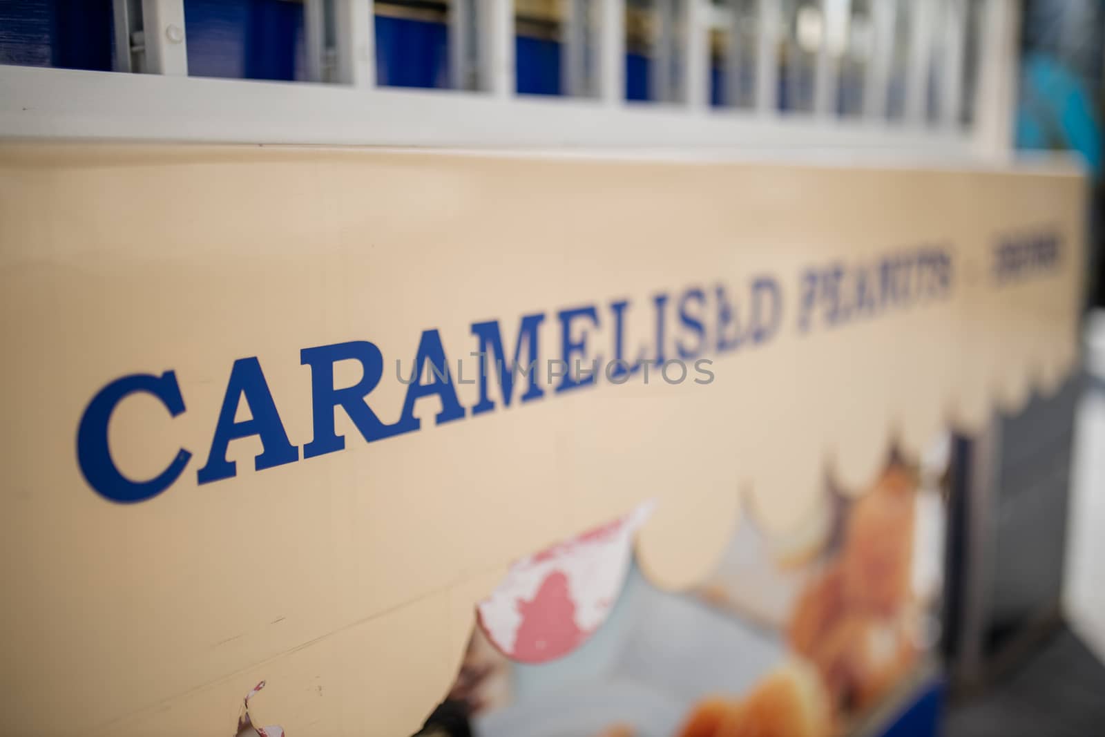 Landscape close-up view of the blue word Caramelised on the signboard of an outdoor sweet snacks stand in London, UK
