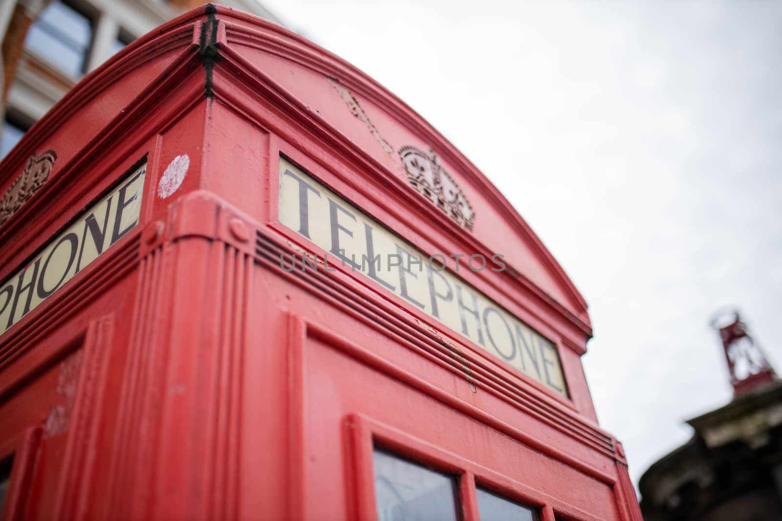 Landscape Close up view of the top of a classic London telephone booth with a bright cloudy sky as background
