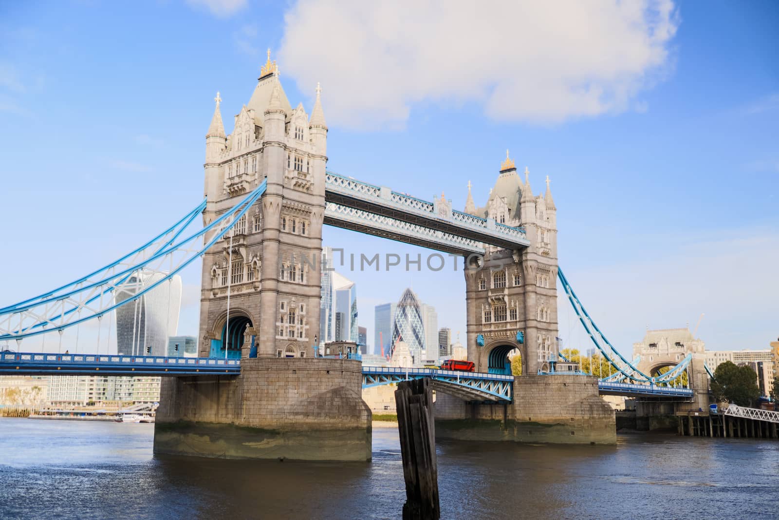 Landscape View of the Tower Bridge -inaugurated in 1894- over the River Thames, under a blue sky and with a Cityscape as background
