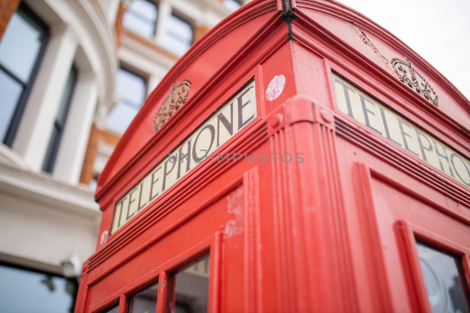 Landscape Close up view of the top of a classic London telephone booth with a blurry brick building as background