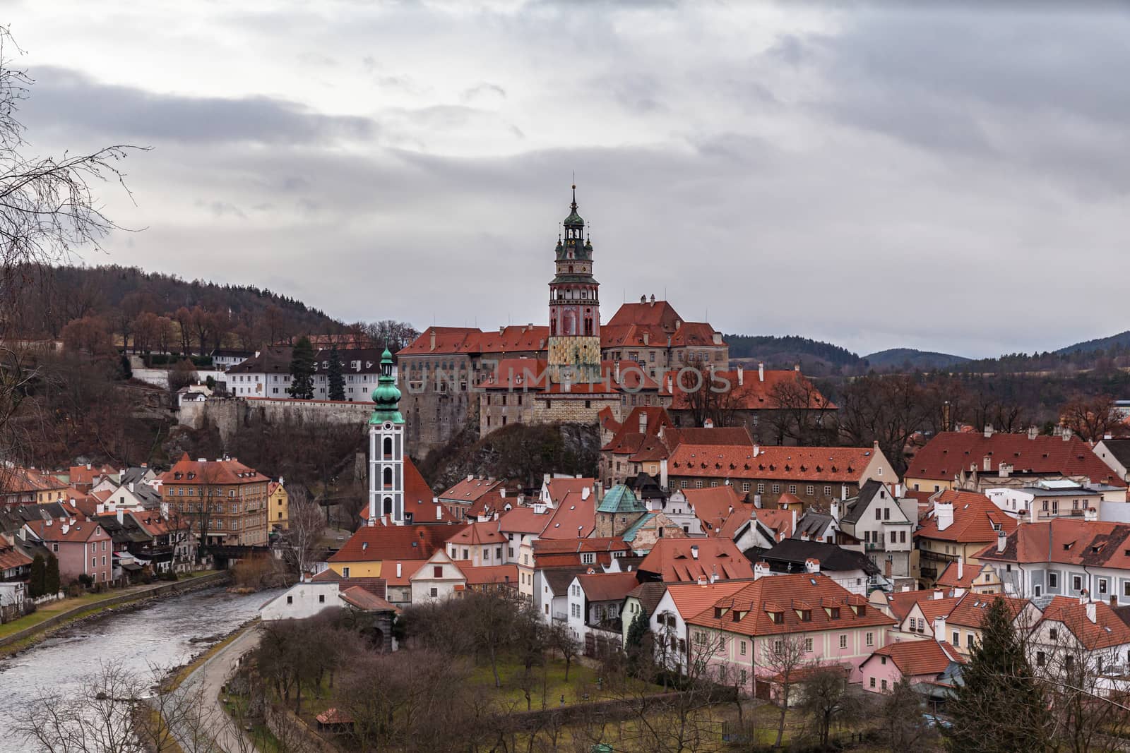 Aerial panorama view of Český Krumlov old town with the Cesky Krumlov castle and tower in background and Vltava river flowing around on a cloudy day, Czech Republic