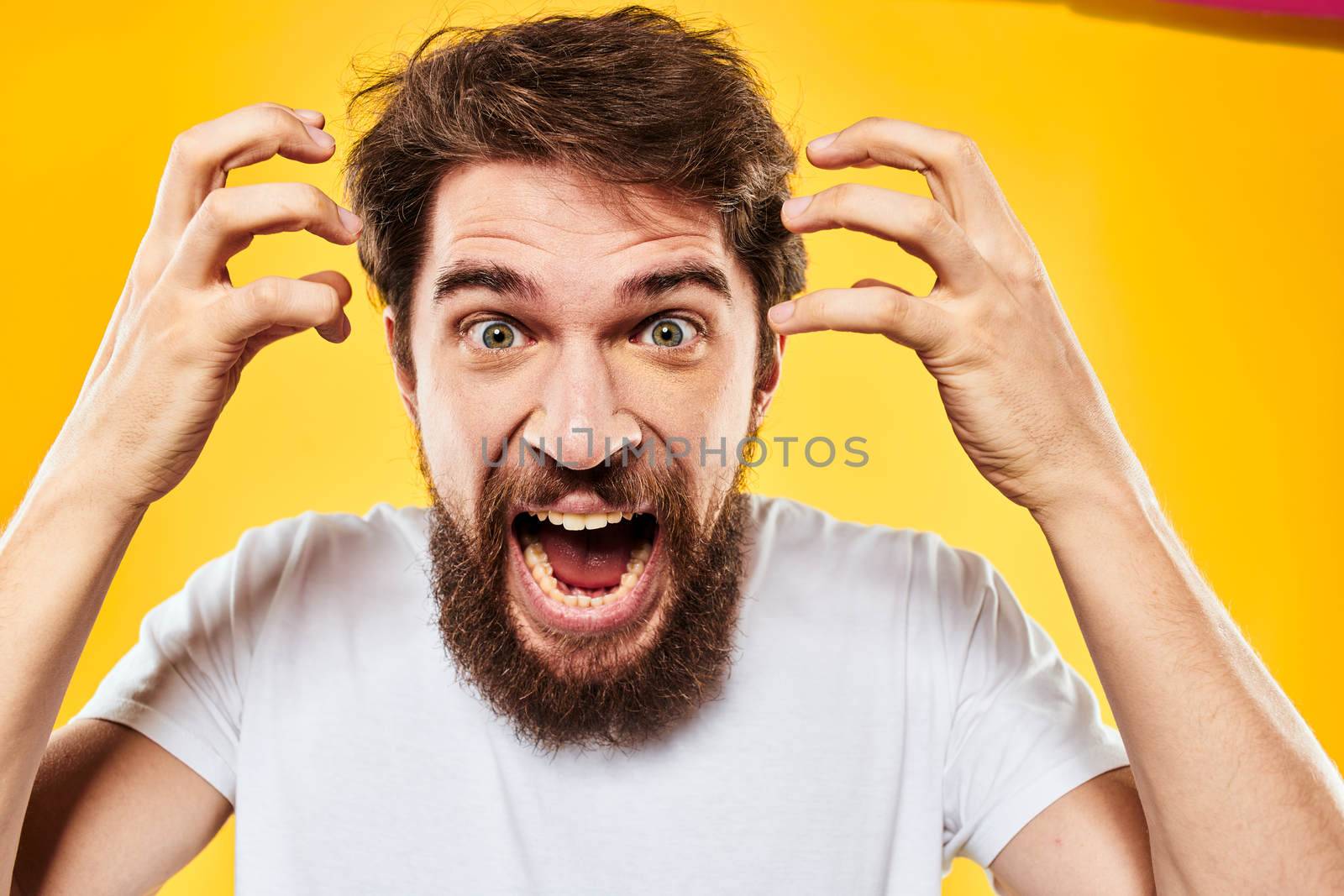 bearded man gesturing with hands studio lifestyle discontent yellow background. High quality photo