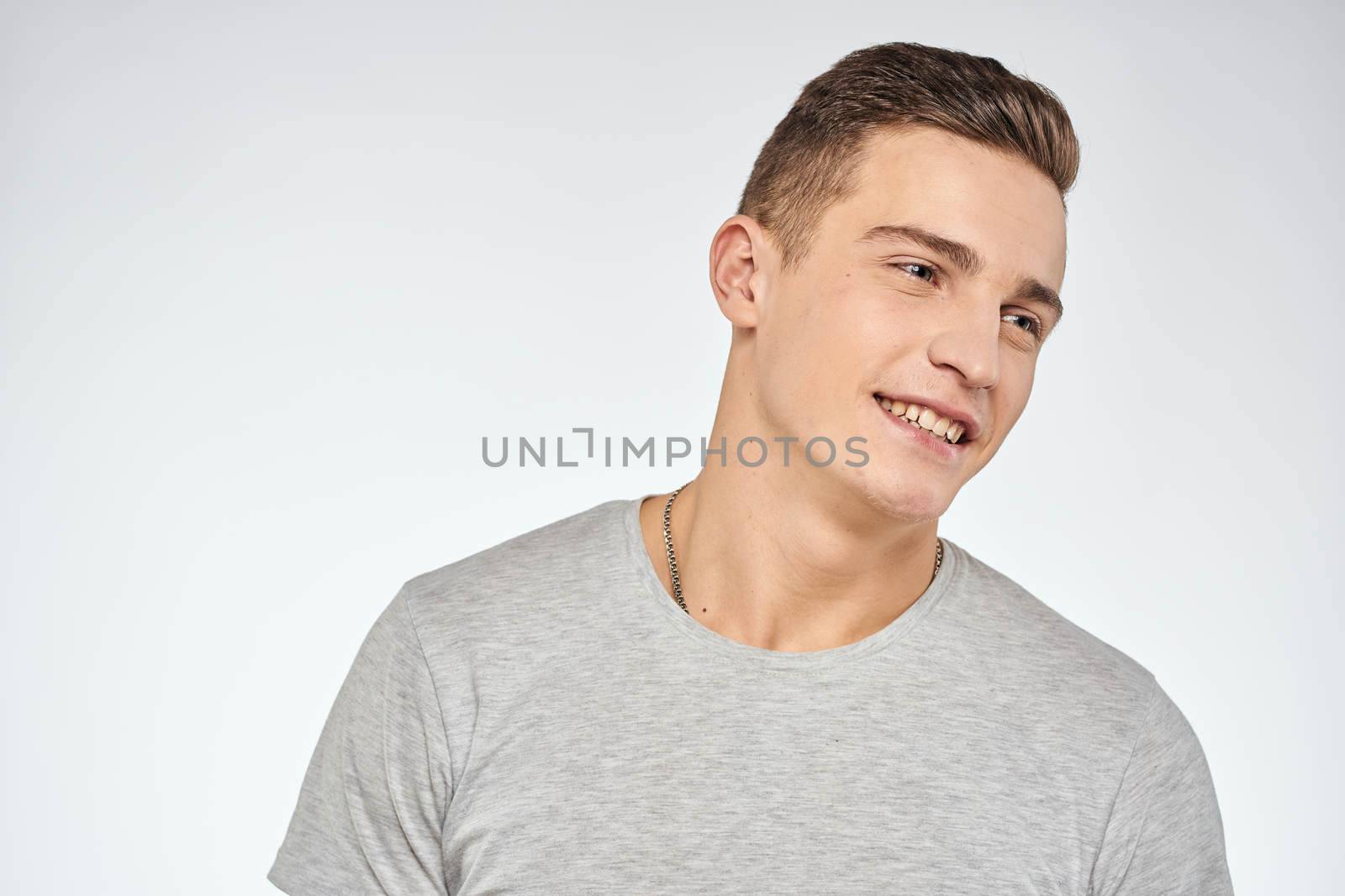 Handsome man in gray t-shirt cropped view of emotion Studio Model. High quality photo