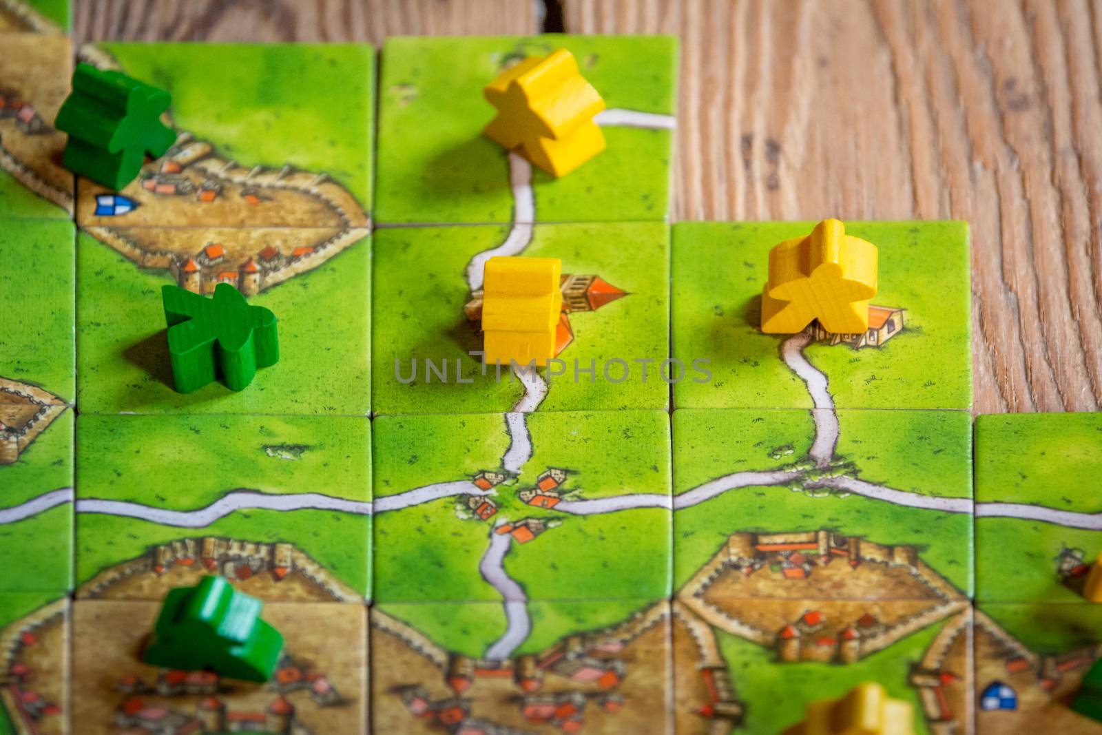 Antwerp, Belgium, November 2020: Illustrative Editorial: Carcassonne Board Game with tiles and meeples on wooden background.