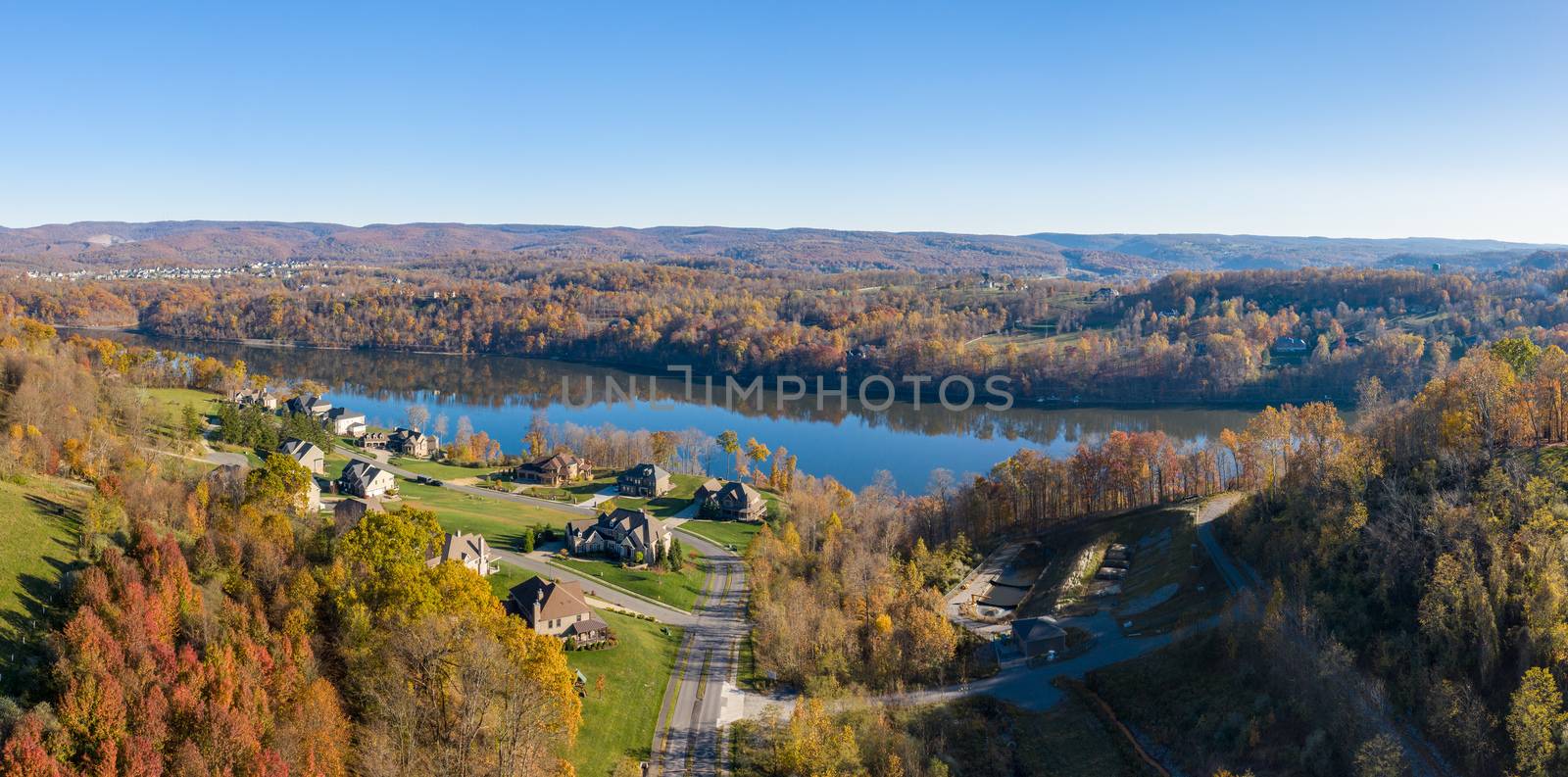 Aerial drone panorama of single family houses by Cheat Lake near Morgantown in autumn