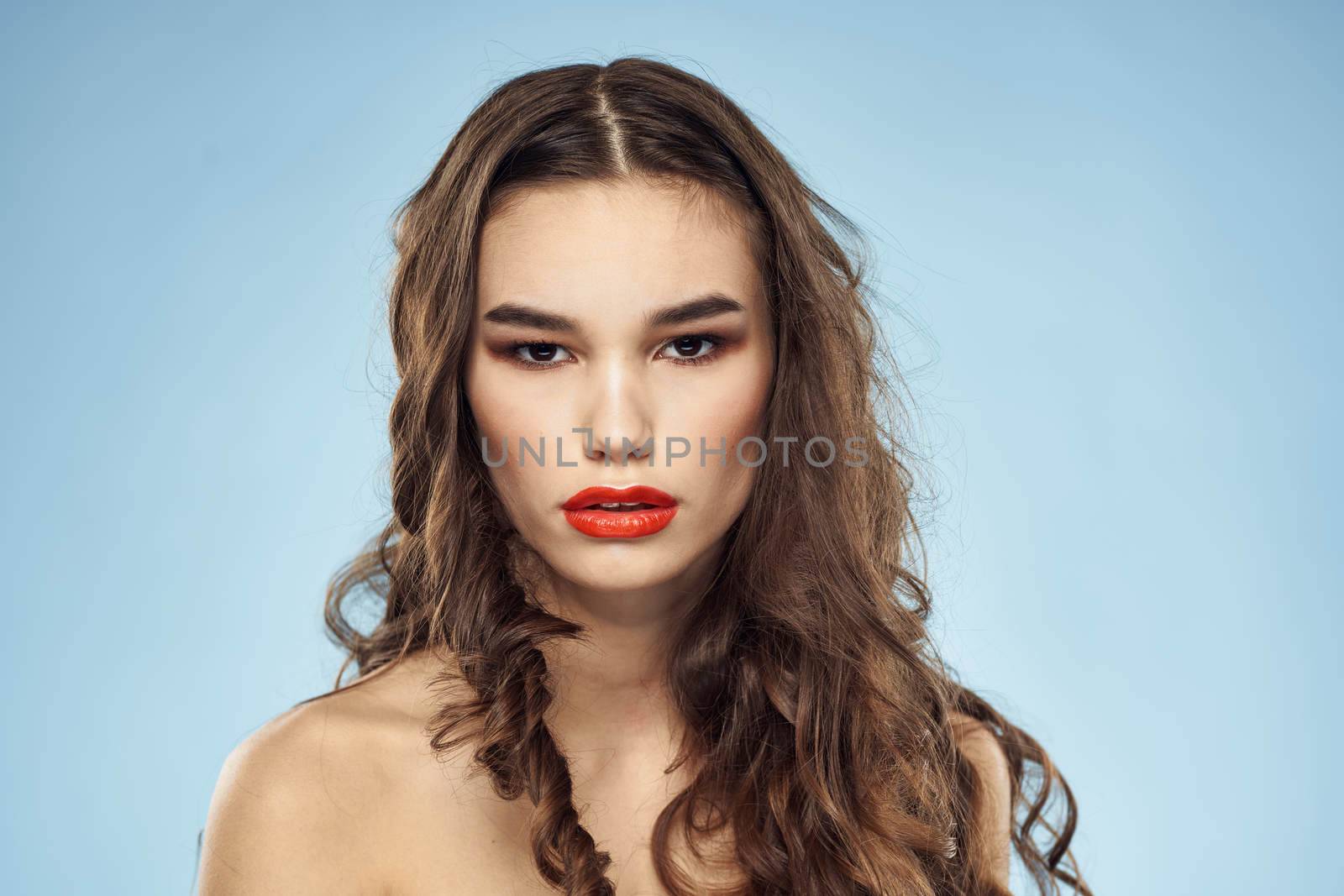 Brunette naked shoulders red lips fashionable hairstyle blue background by SHOTPRIME