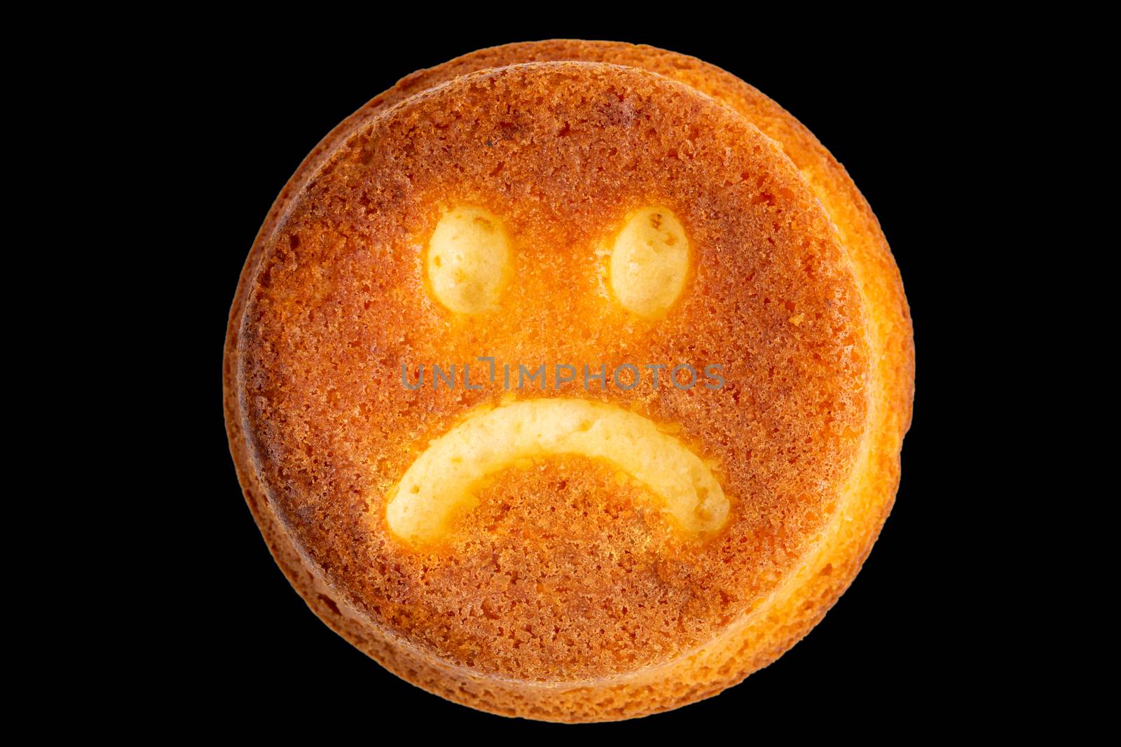unhappy face biscuit cookie isolated on black in flat lay perspective.
