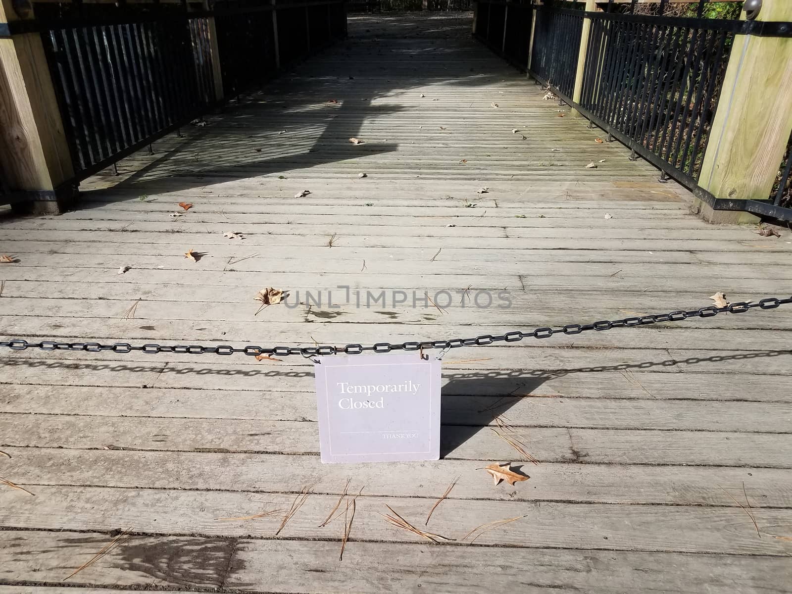 temporarily closed sign with chain and wood boardwalk by stockphotofan1