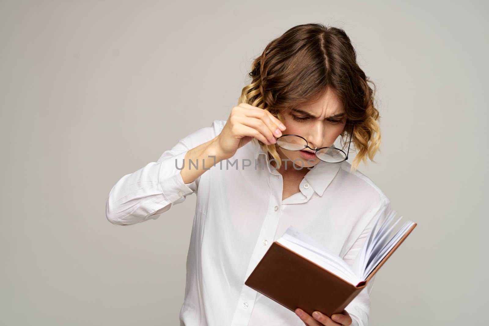 Surprised woman in glasses looks into a notebook working office business finance. High quality photo