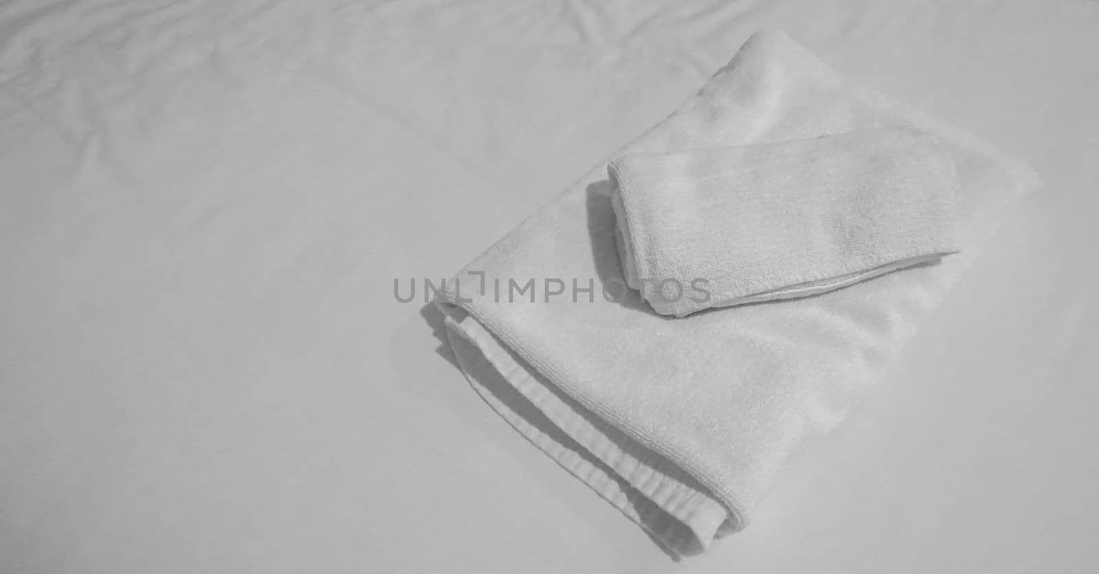 Pile of White Towels on bedsheet by Urvashi-A