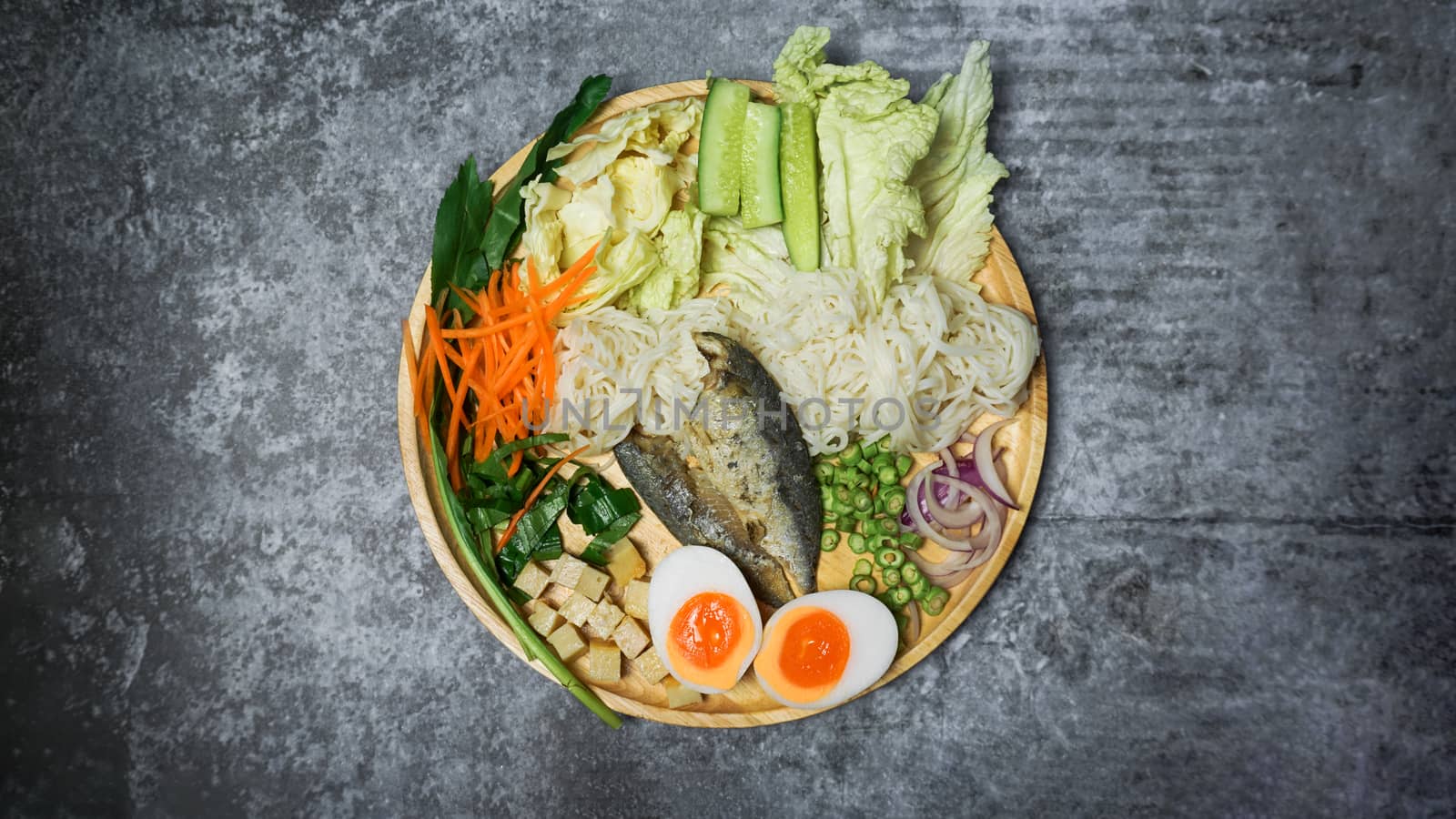 Spicy rice noodle salad withe herb on cement table.