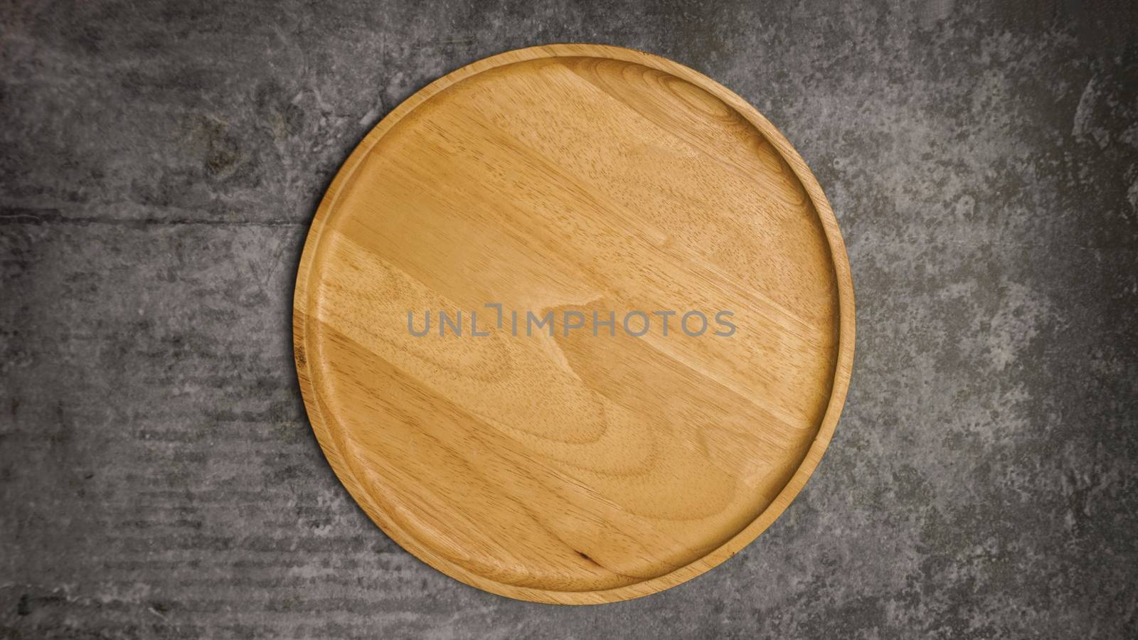 Wooden dish on gray cement table. by Urvashi-A