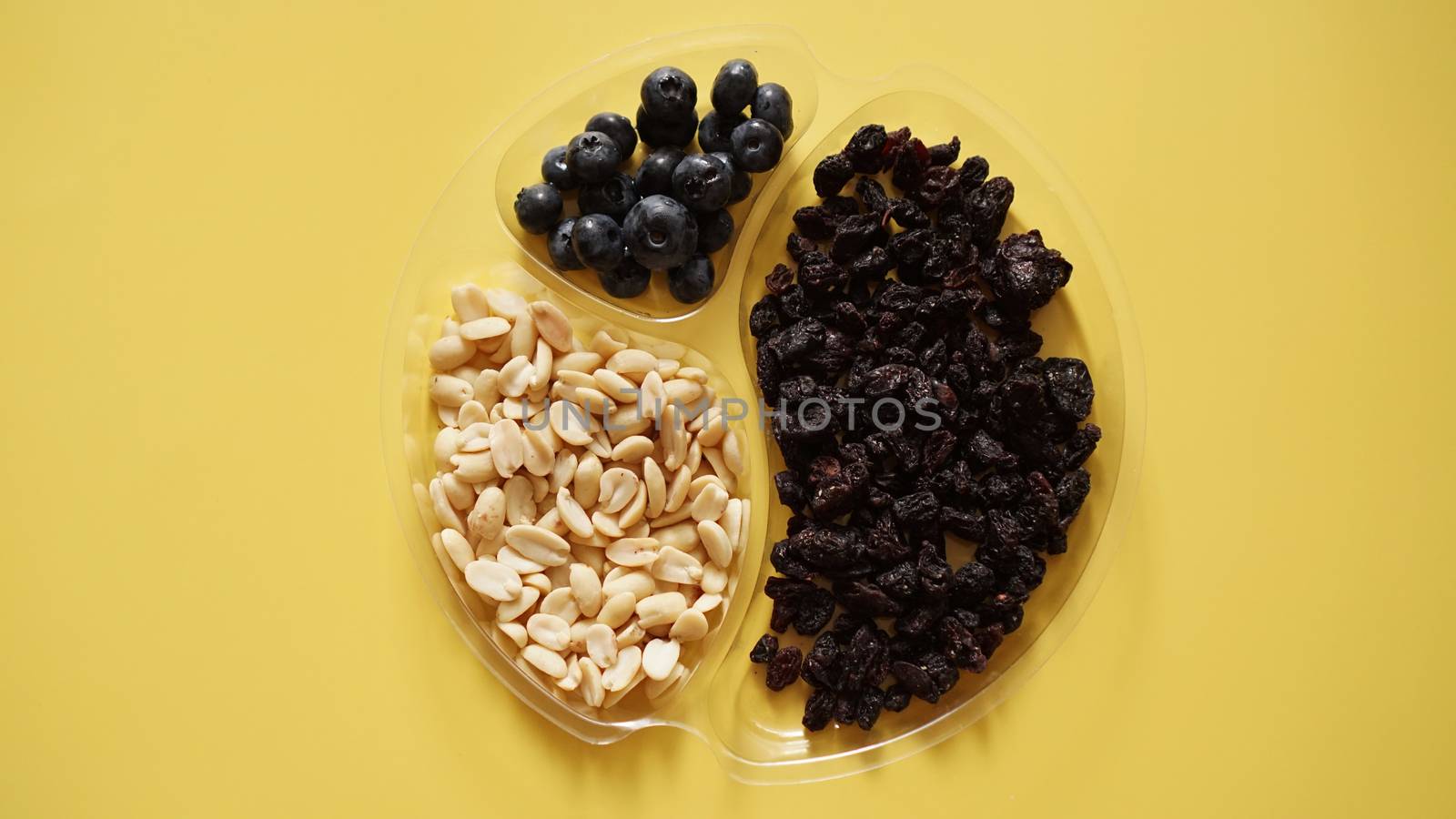 Berries ad nuts in plastic container for food storage by natali_brill