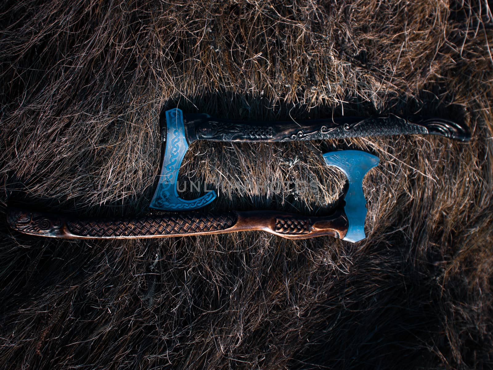 Close up look at the ancient Scandinavian vikings axe at the summer sunset on the deep grass