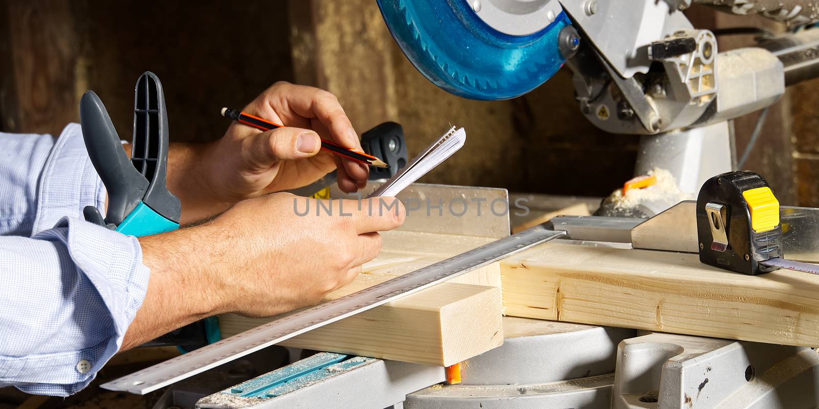 Carpenter work concept. Carpenter work with circular saw for cutting wood bar, the man sawed bars, construction and home renovation.