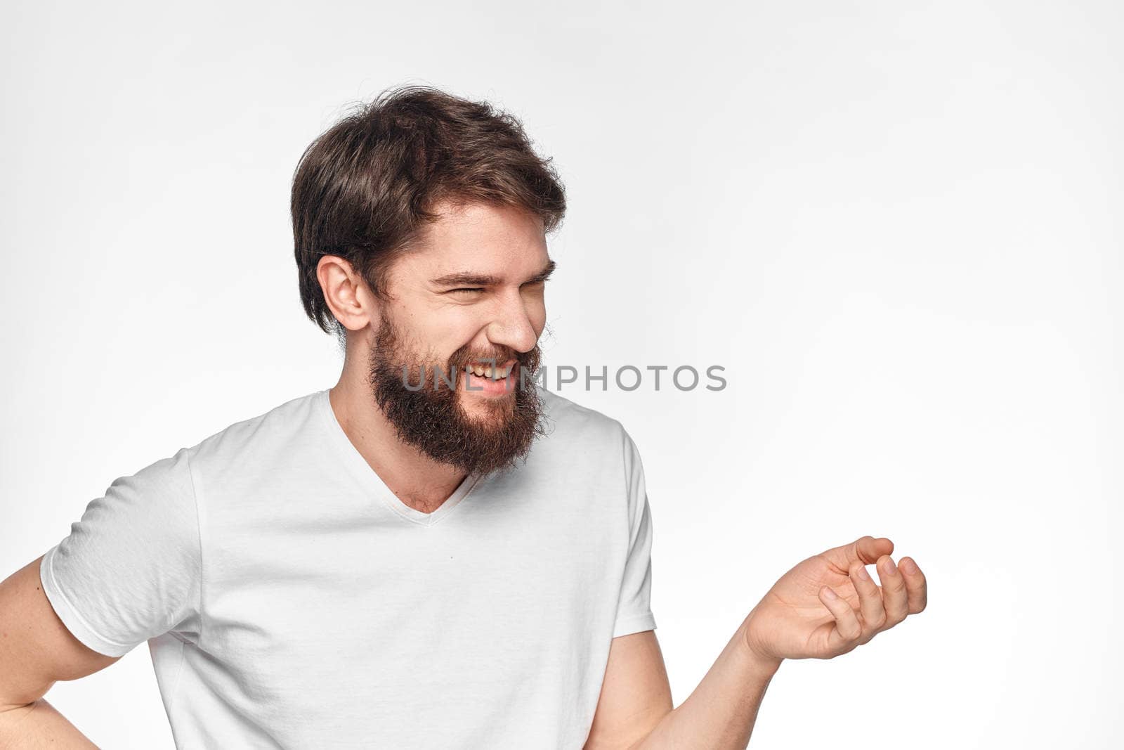 cheerful emotional bearded man gesturing with his hands close-up light background. High quality photo