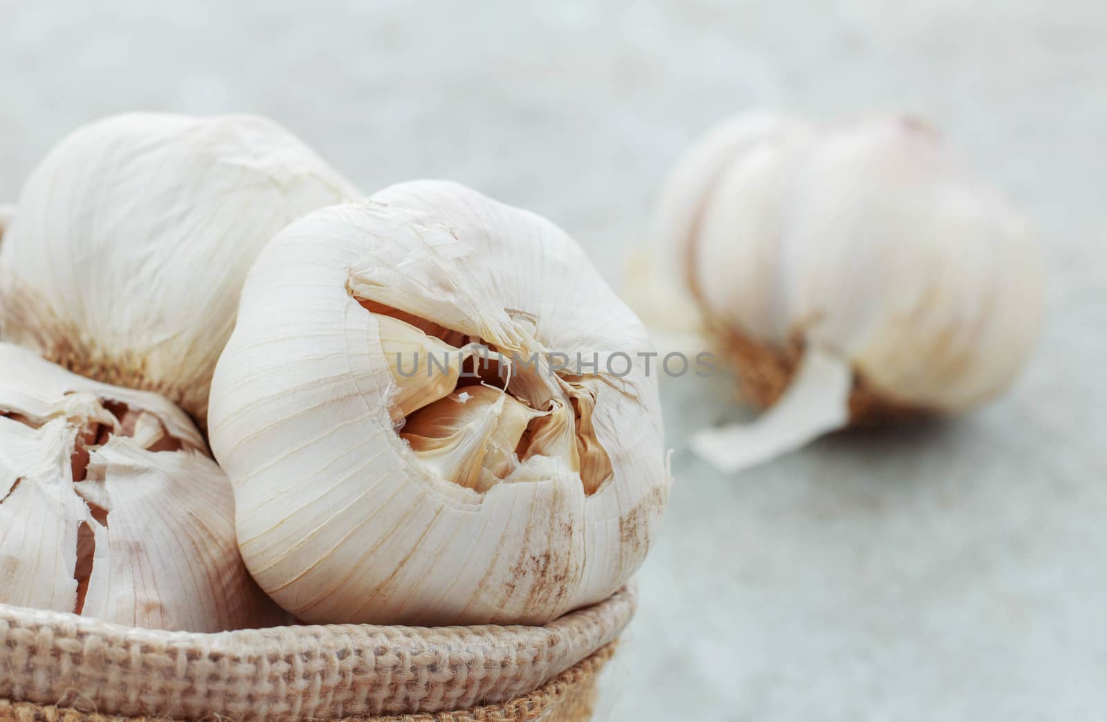 Garlic in a sack on concrete floor.