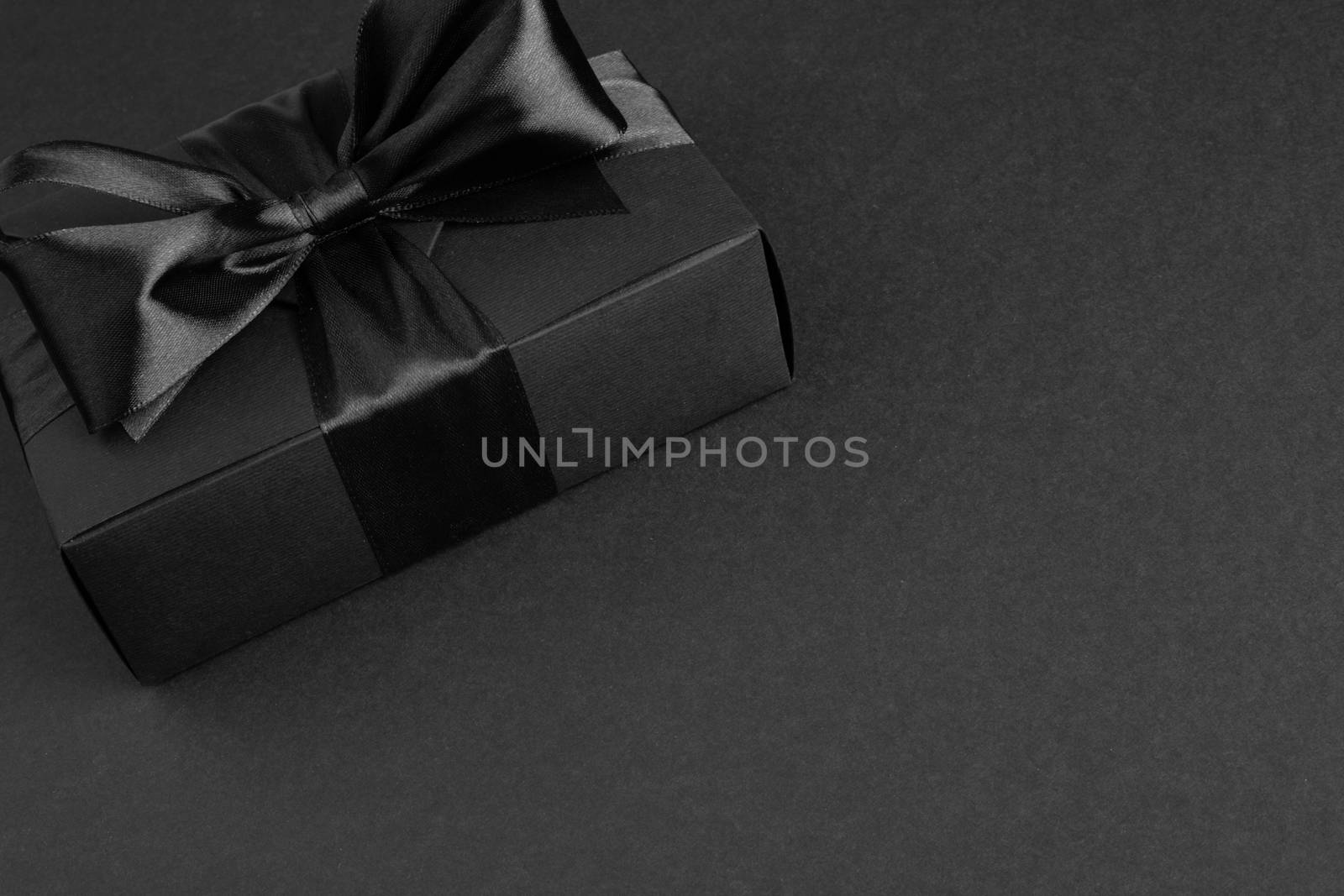 Black friday sale box gift present with ribbon bow on black conceptual design