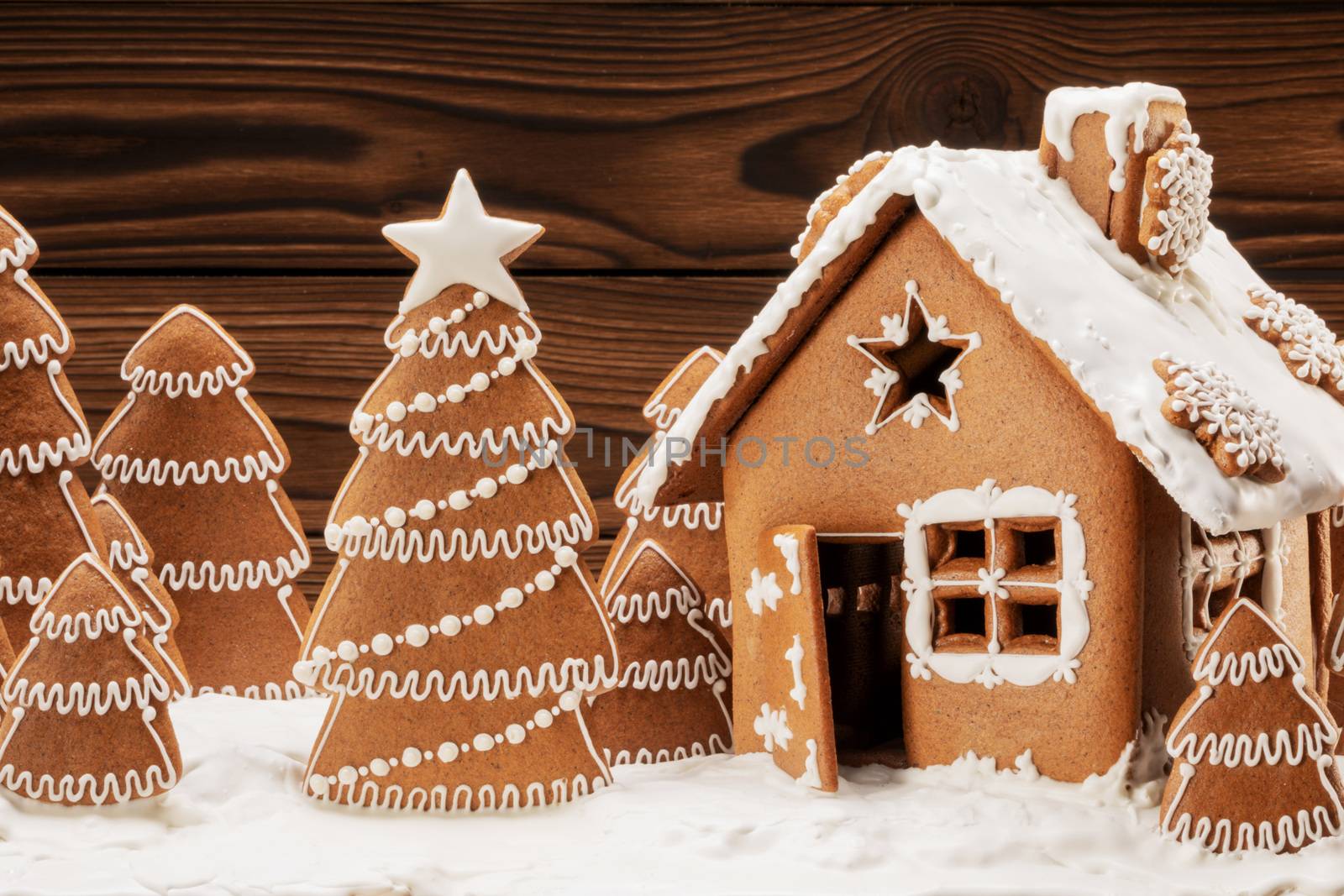 Gingerbread house christmas fir trees cookies in snow winter holiday celebration concept