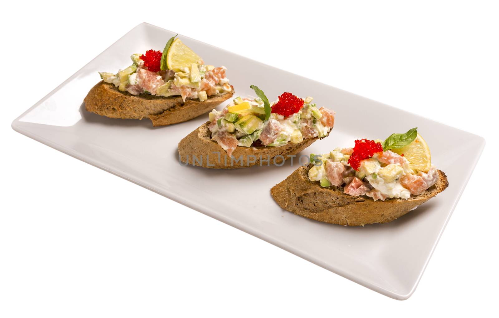 Bruschetta with salmon and avocado dried rye baguette, cream cheese, salmon, Tobiko caviar, avocado, basil . Isolated image on white background.