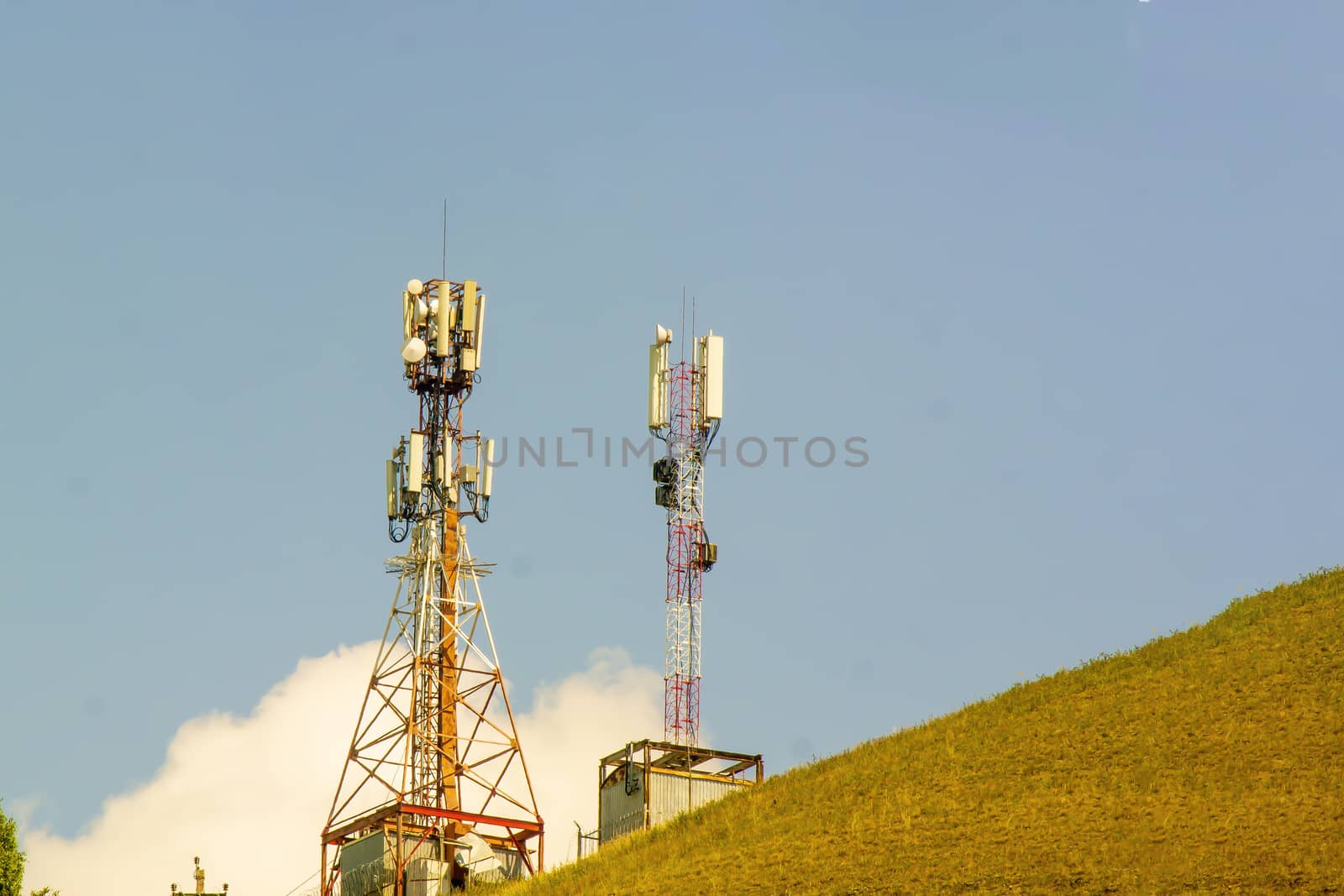 two Mobile phone tower amid blue sky, communication. horisontal snapshot