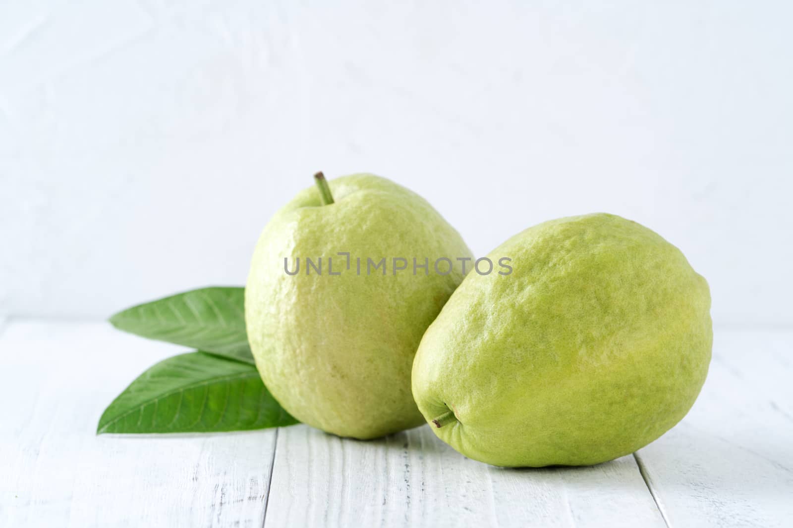 Top view, flat lay of delicious beautiful Red guava with fresh green leaves isolated on white table background, studio overhead table shot with copy space.