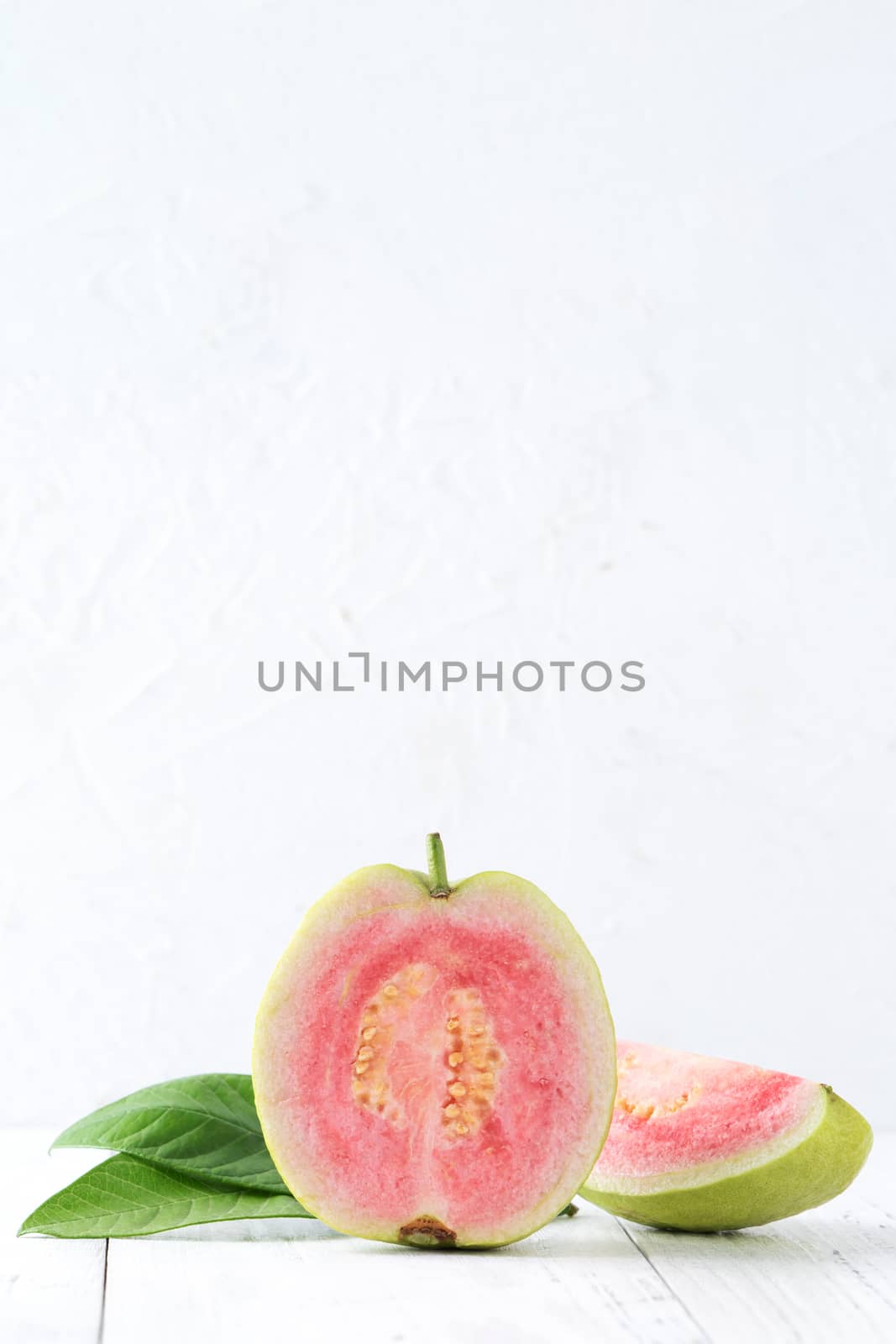 Top view, flat lay of delicious beautiful Red guava with fresh green leaves isolated on white table background, studio overhead table shot with copy space.