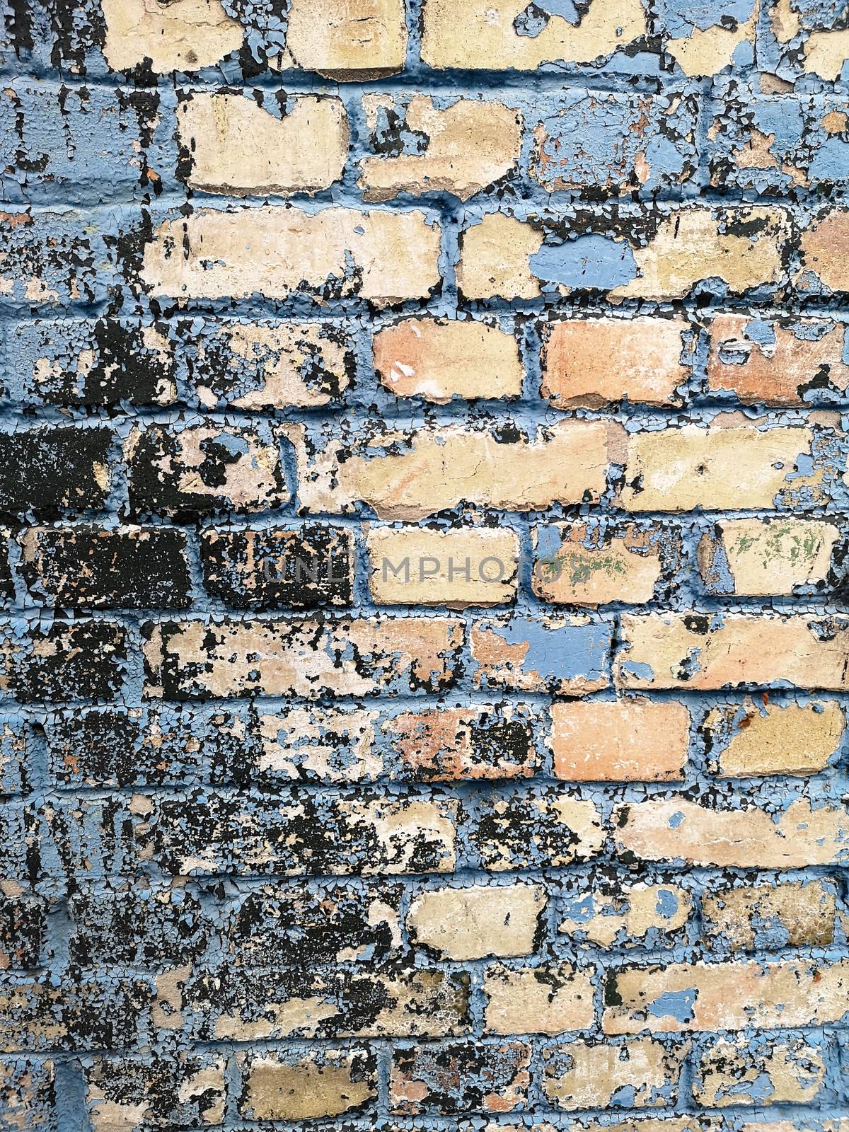 Old brick wall with remains of paint. Background texture closeup.