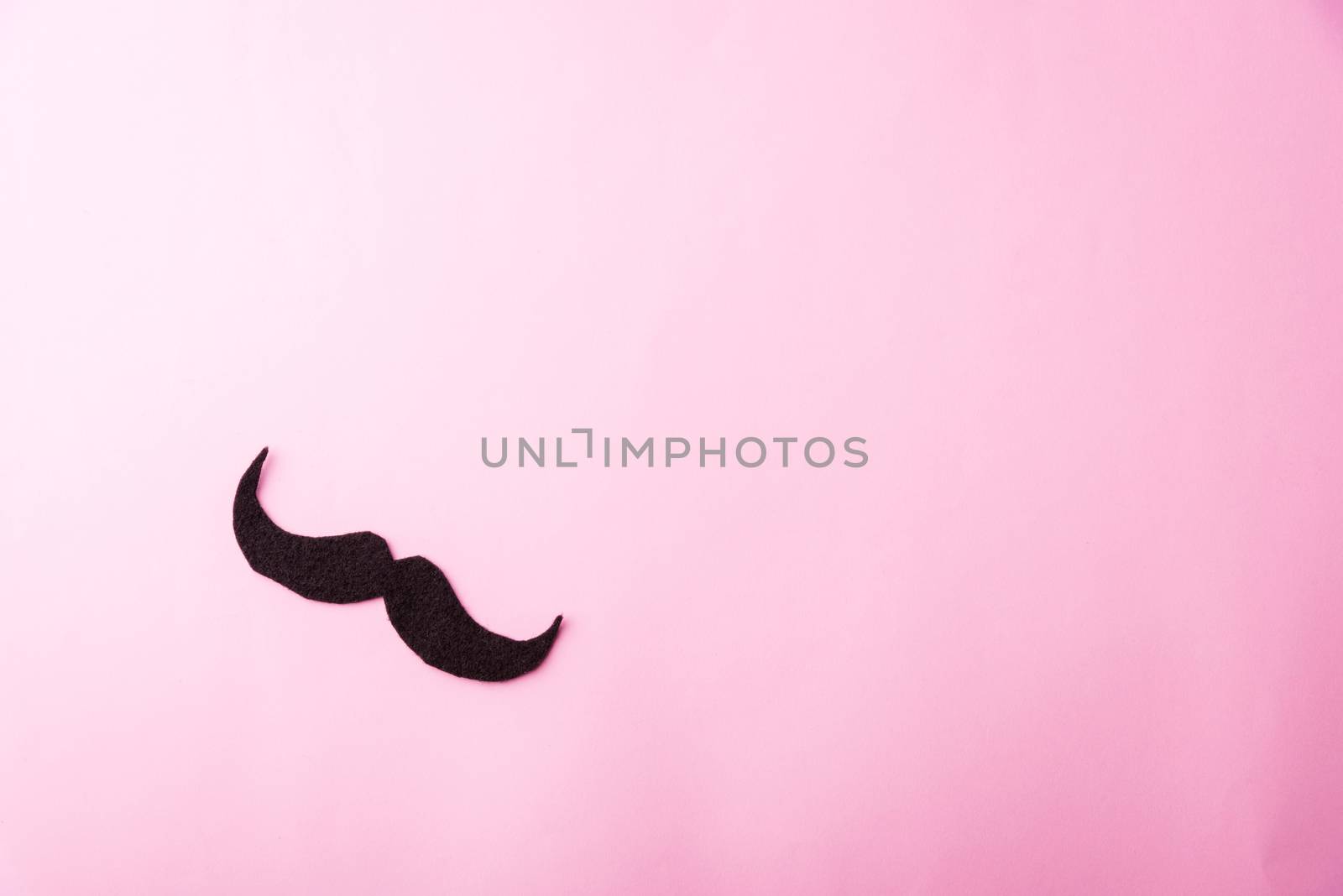 Black mustache paper, studio shot isolated on pink background, Prostate cancer awareness month, Fathers day, minimal November moustache concept