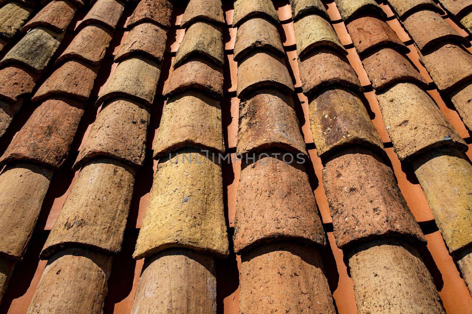 Old orange roof tiles for laying on the roof of the house, the traditional roof of the Mediterranean countries. Background image texture closeup.
