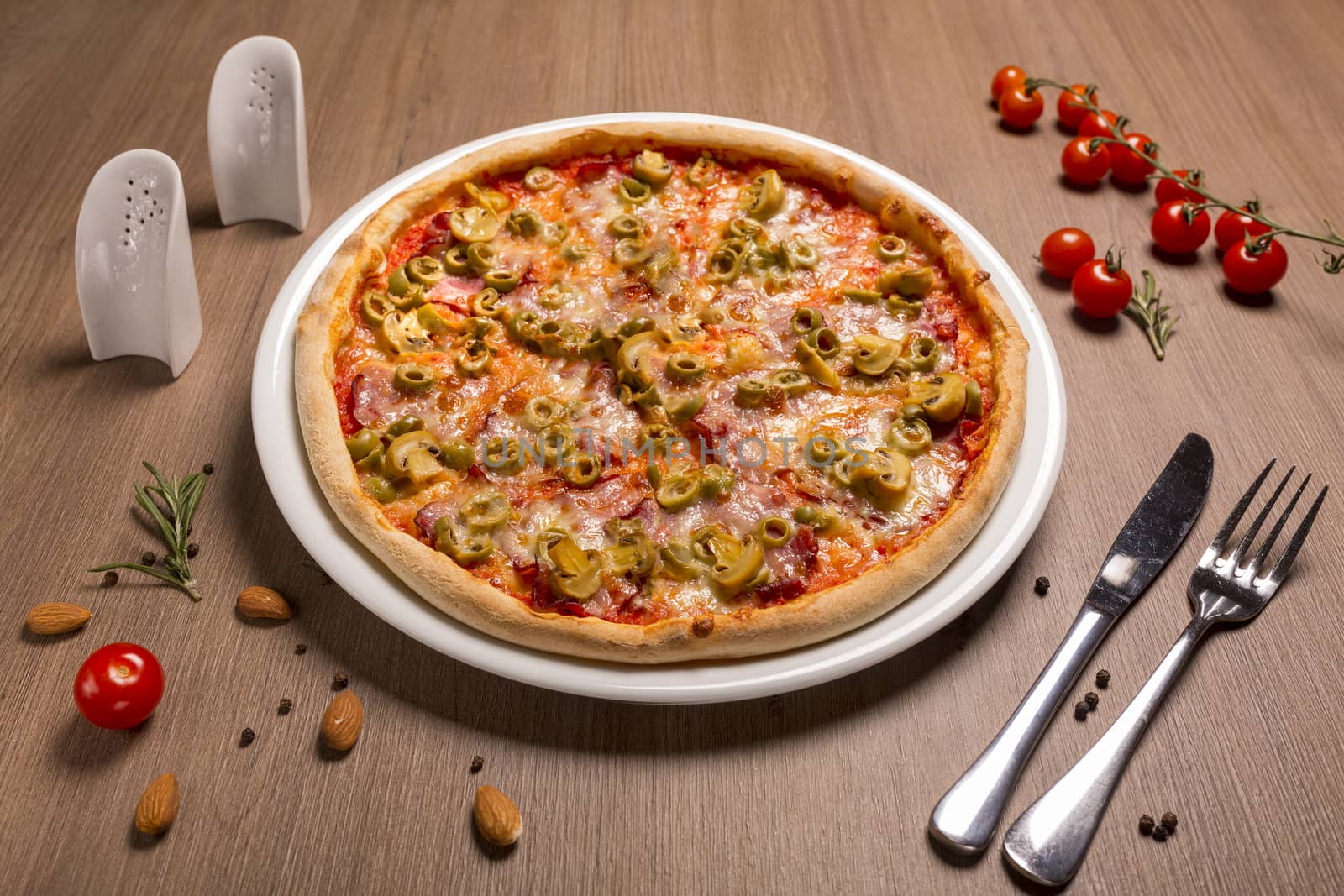 Capricciosa pizza thin cake, tomato sauce, ham, olives, marinated mushrooms mozzarella basil.