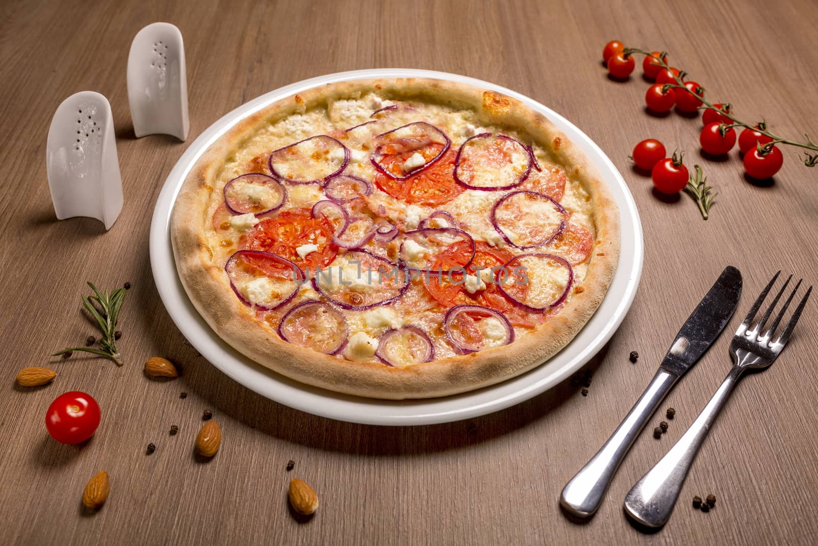 Pizza with feta and salami thin cake, cream, Italian salami, tomatoes, marinated onions mozzarella, feta, basil.