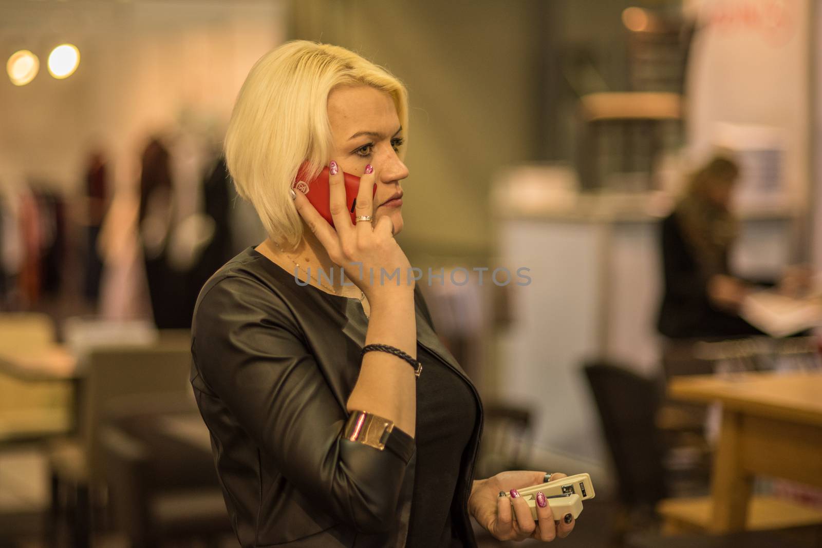 03/04/2017. Brno, Czech Republic. Woman speaking on her phone attending an event at the convention trade center in Brno. BVV Brno Exhibition center. Czech Republic by gonzalobell