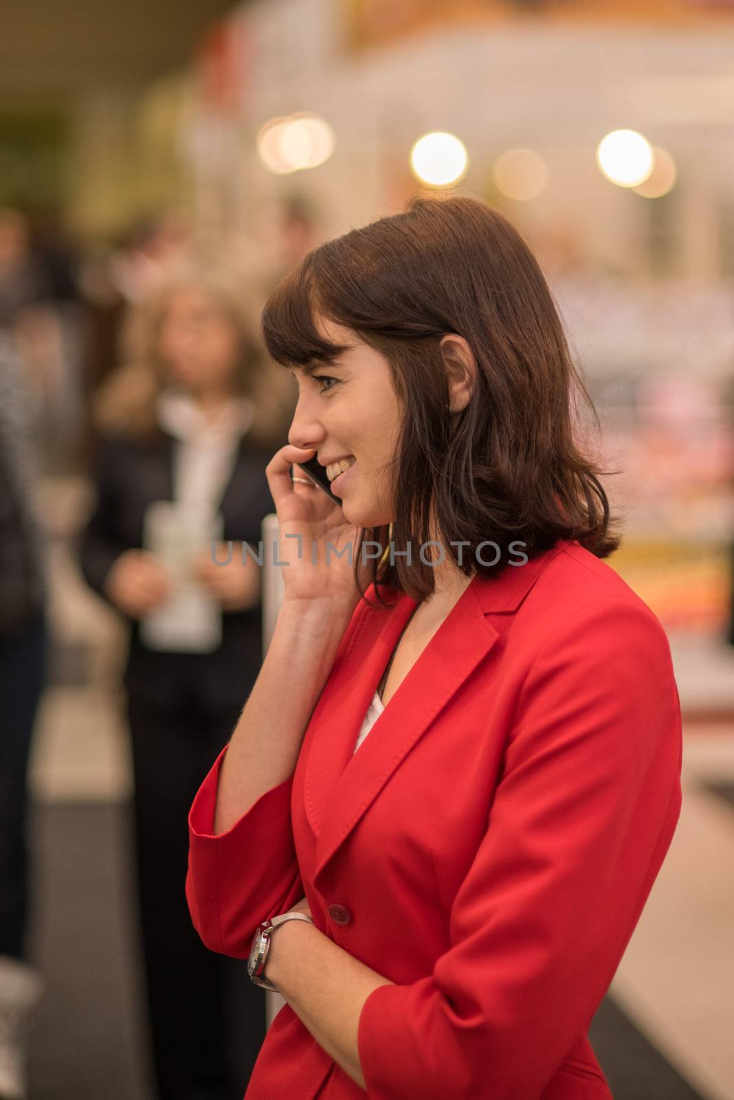 Woman speaking on her phone attending an event at the convention trade center in Brno. BVV Brno Exhibition center. Czech Republic