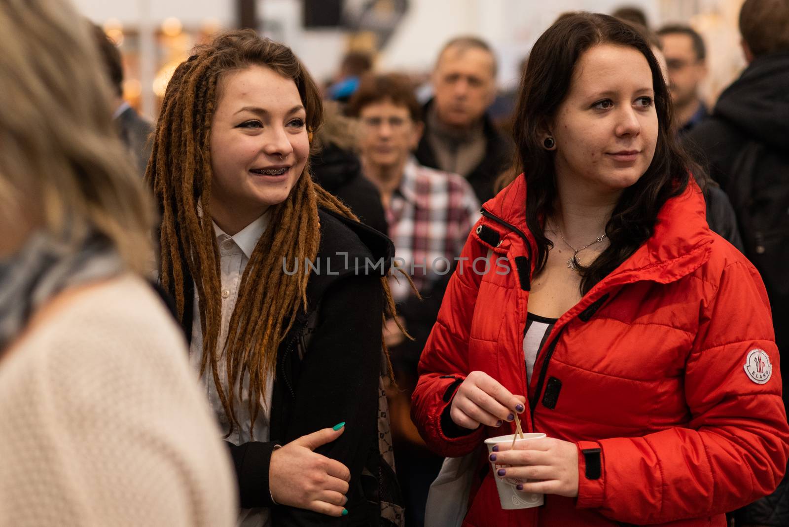 Two women walking in the crowd attending an event at the convention trade center in Brno. BVV Brno Exhibition center. Czech Republic