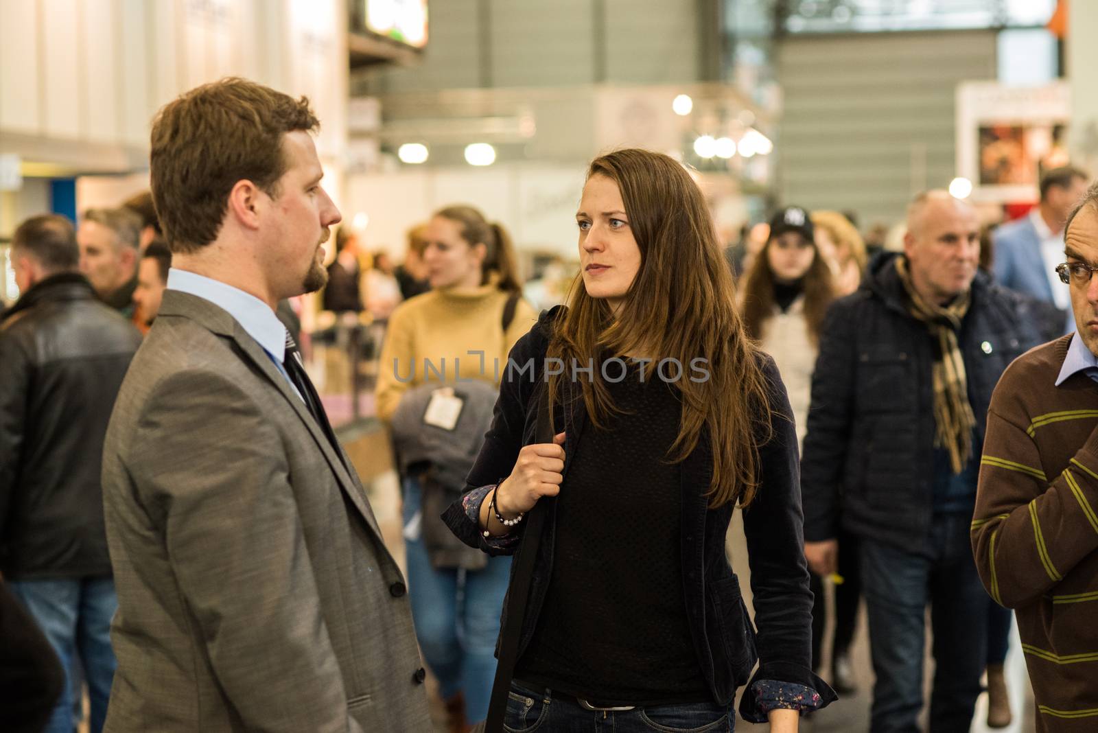 Man and woman walking in the crowd attending an event at the convention trade center in Brno. BVV Brno Exhibition center. Czech Republic