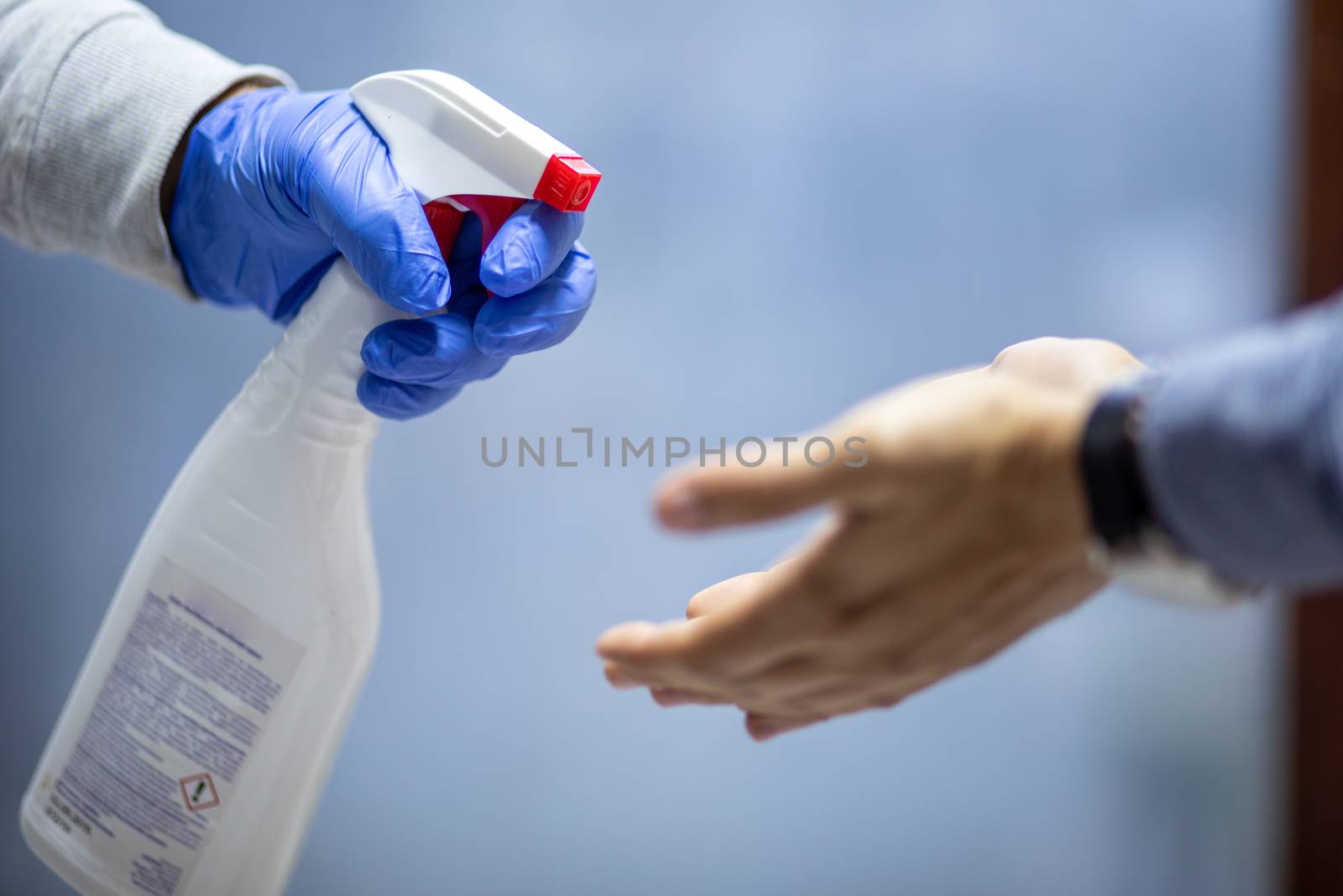 Spraying hands with antiseptic solution