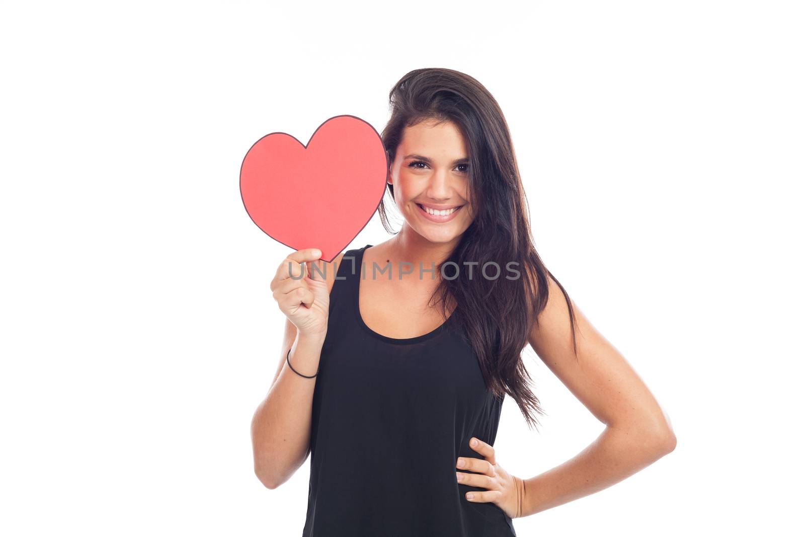 beautiful happy brunette woman holding and showing a big red heart