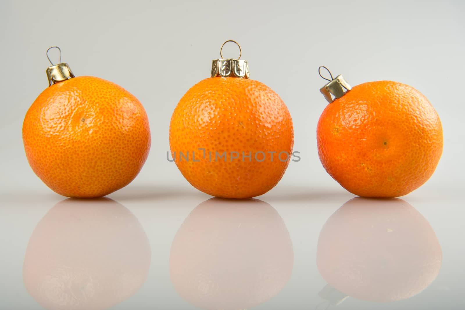 Three Tangerine as a xmas ball on Christmas and New Year isolated on a white background. Fir tree toy fruits concept design on holiday.