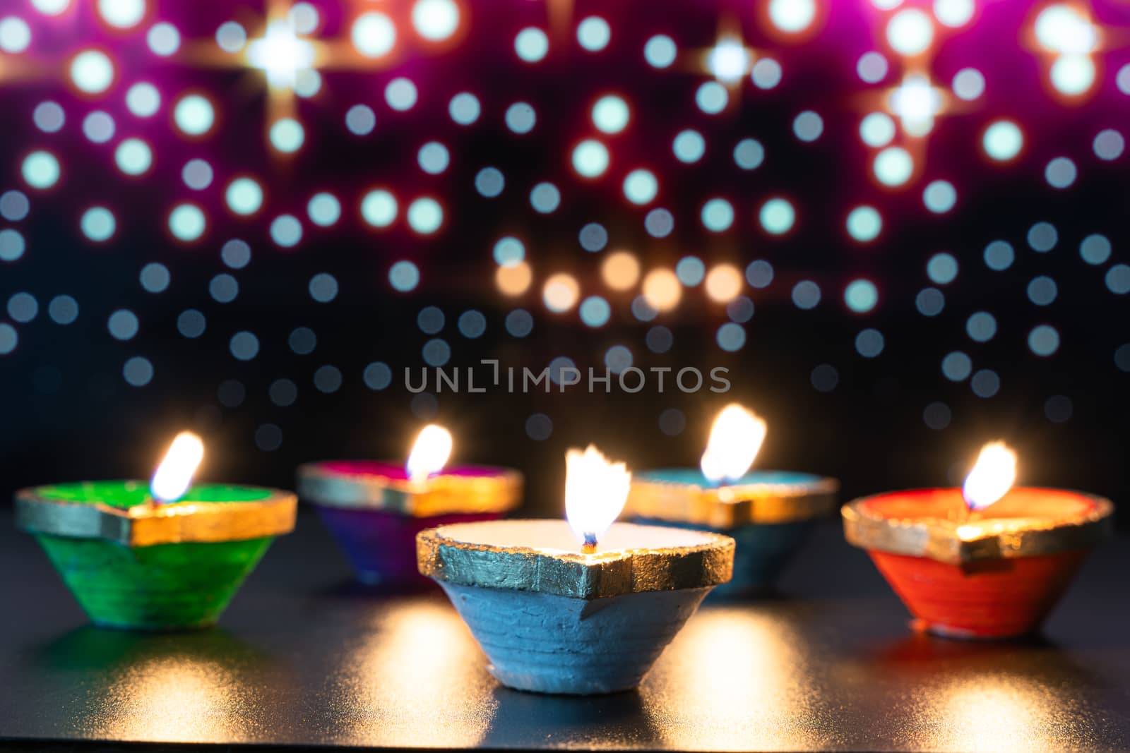 Indian festival Diwali, Diya oil lamps lit on colorful rangoli. Hindu traditional. Happy Deepavali. Copy space for text.