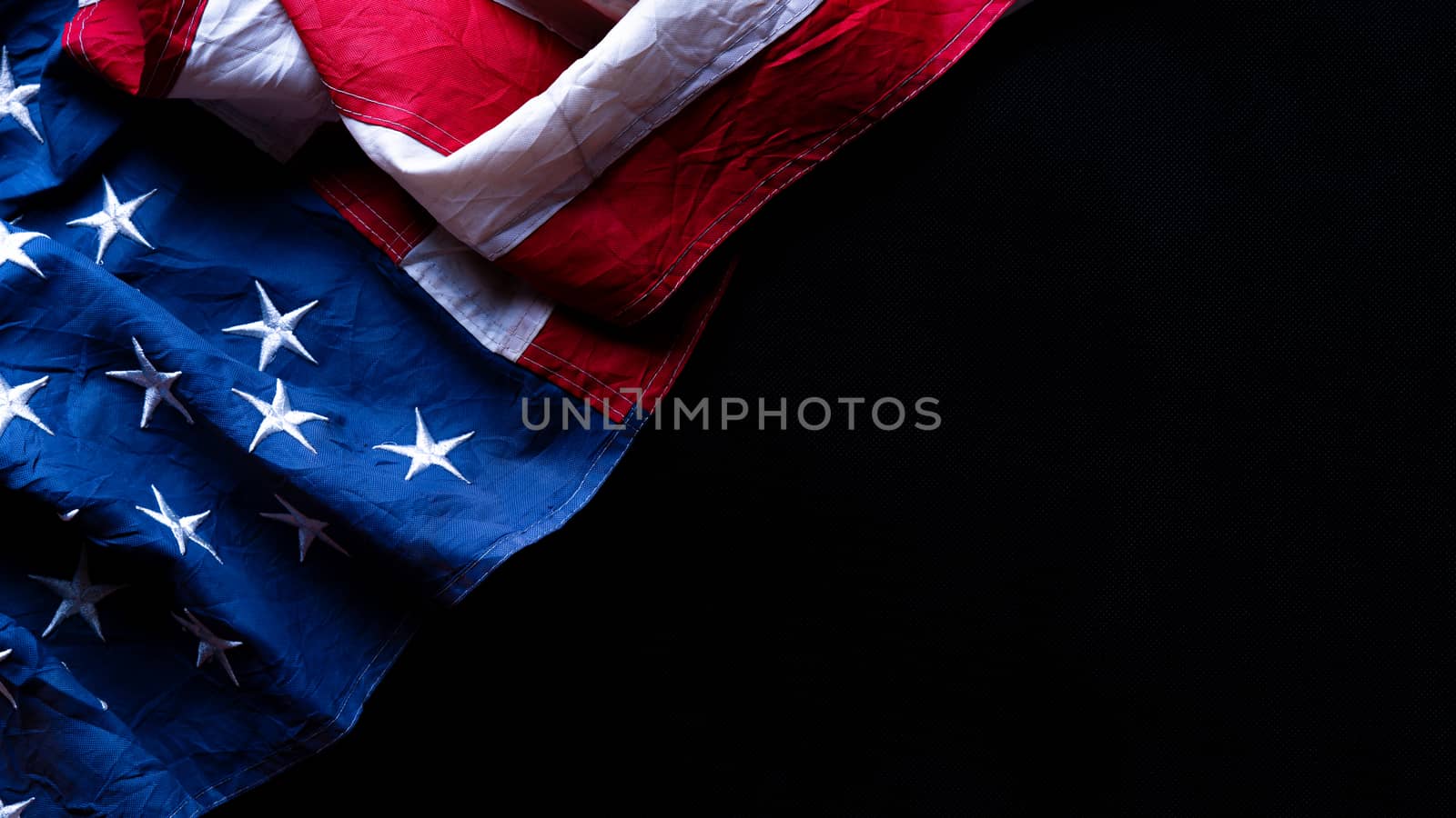 US American flag against black background. For Memorial, Presidents, Veterans, Labor, Independence or 4th of July celebration day. Top view, copy space for text.