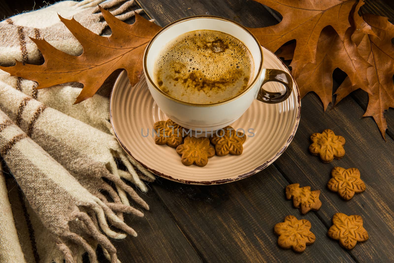 Cup of hot coffee Christmas sweet cookies plaid with brown oak leaves top view on wooden background