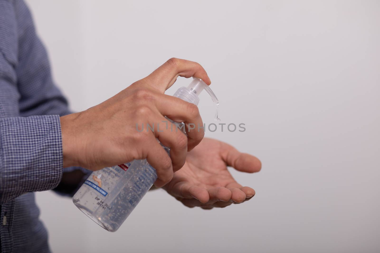 Man applying disinfectant alcohol gel on hands by adamr